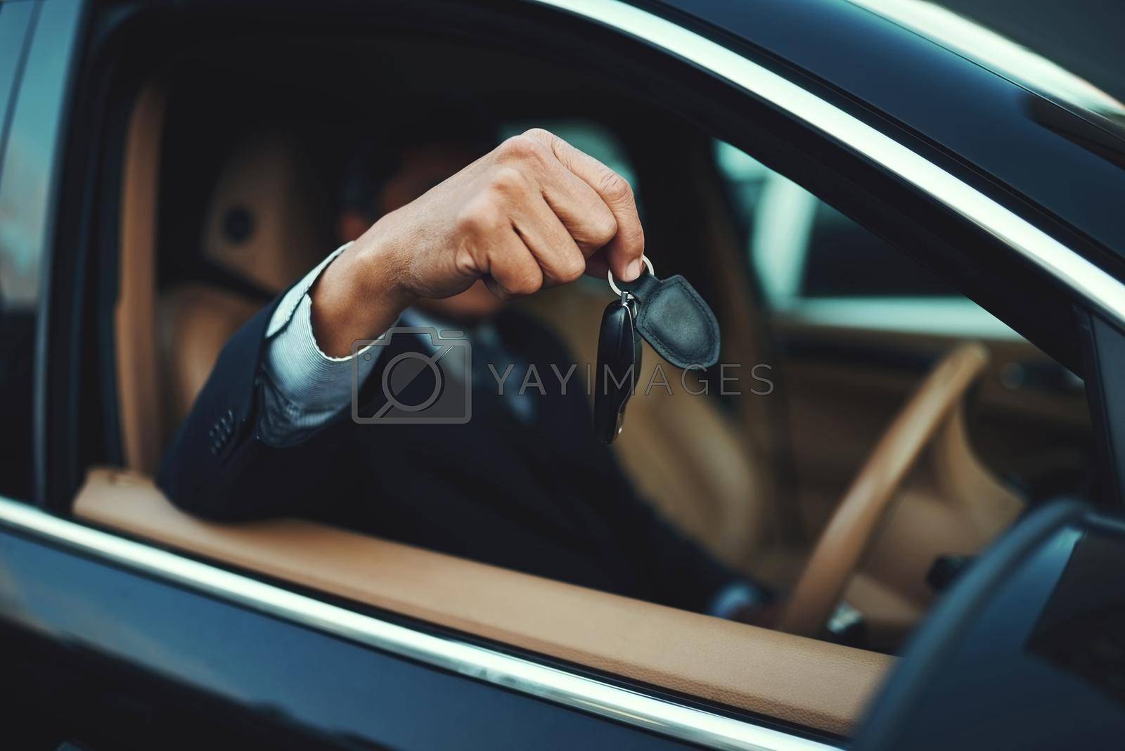 Shot of a businessman holding the keys to a luxury car.