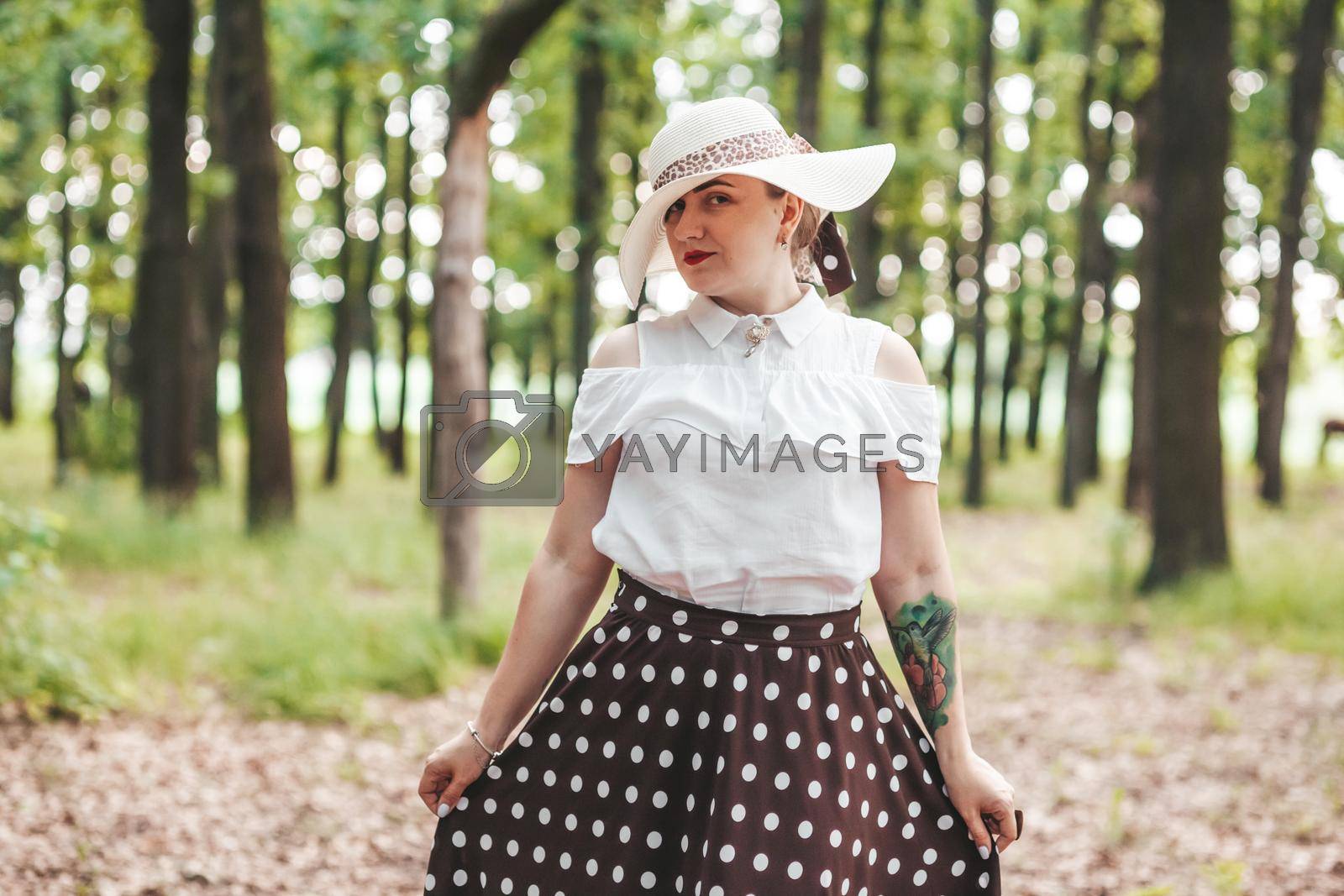 Royalty free image of young girl covered her face with a hat, in the woods by mosfet_ua