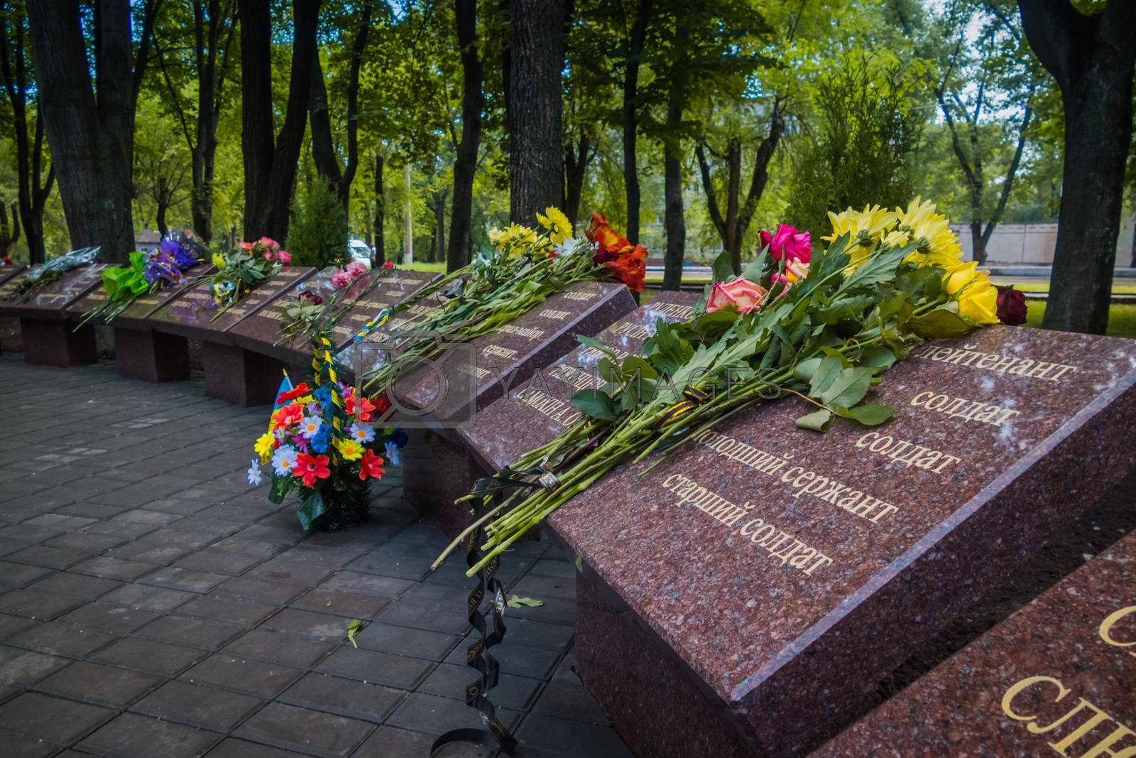 Krivoy Rog, Ukraine - may 18, 2020: A man with flowers near the memorial to fallen soldiers - defenders of Ukraine while honoring the memory of those killed in the battles for Debaltseve