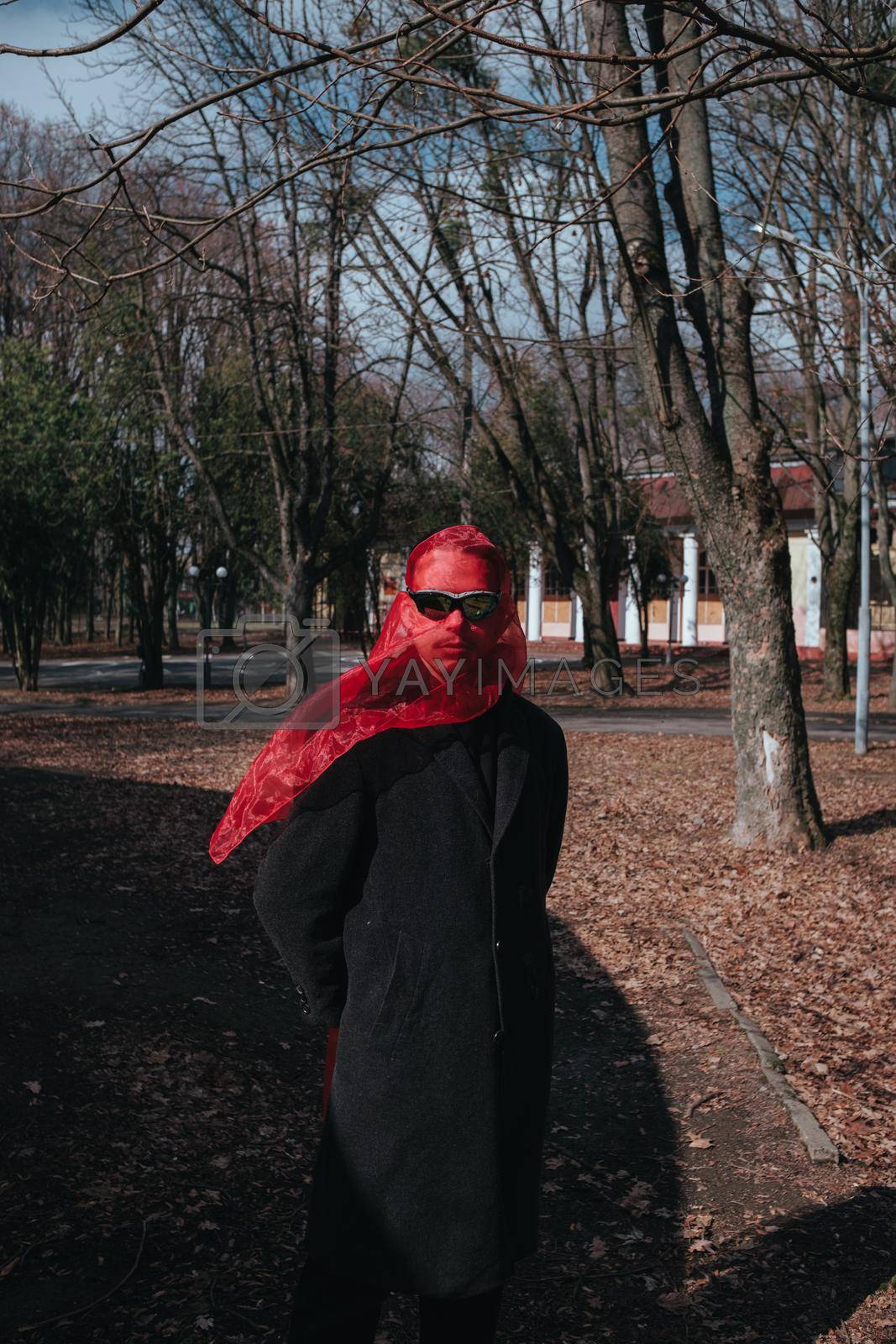 Superhero man with red mask and sunglasses fashion fighter in the park