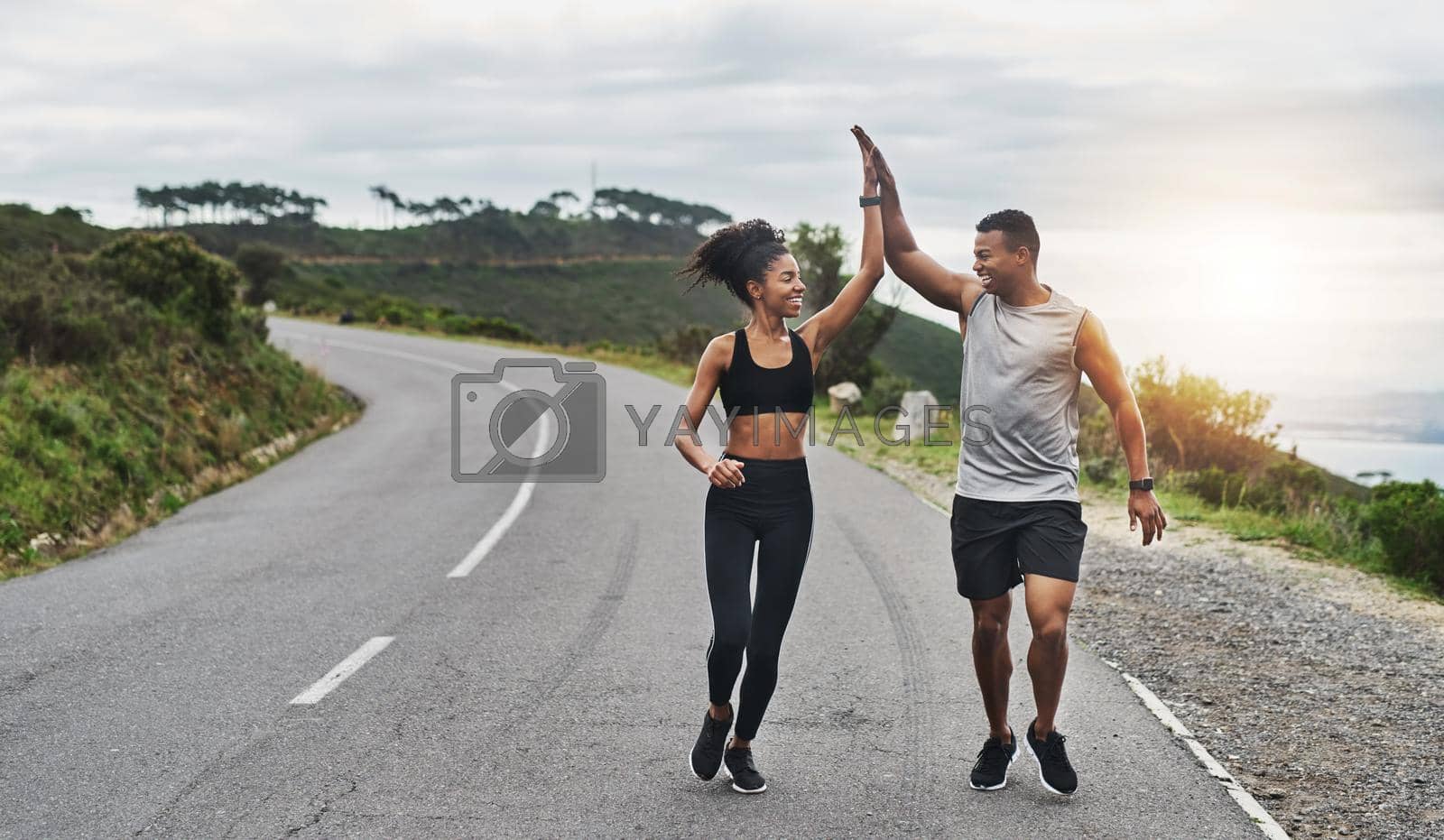 Royalty free image of What an amazing run that was. Shot of a sporty young couple high fiving each other while exercising outdoors. by YuriArcurs