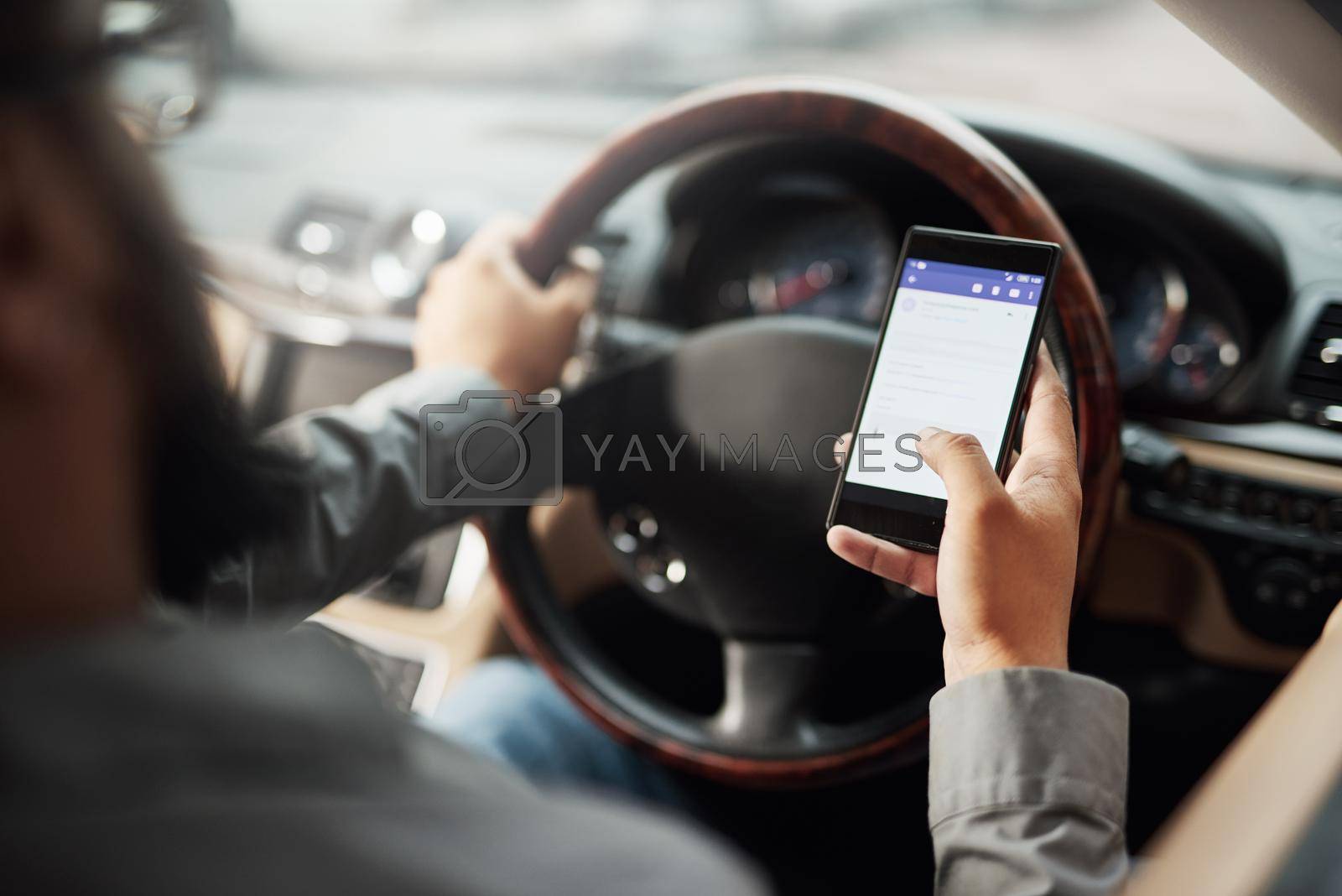 Royalty free image of Texting and driving an accident waiting to happen. Shot of a man using his phone while driving. by YuriArcurs