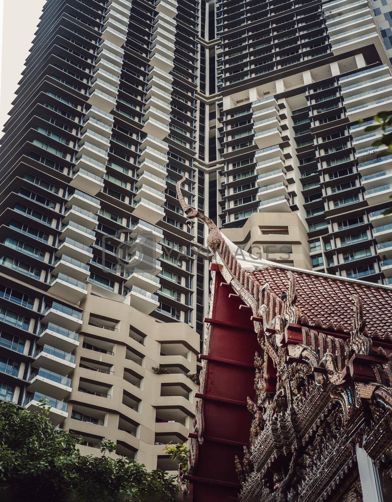 Bangkok, Thailand. Mar - 12, 2022 : View of Buddhist thai temple with Modern tall condominium building in the background can coexist perfectly. Selective Focus.