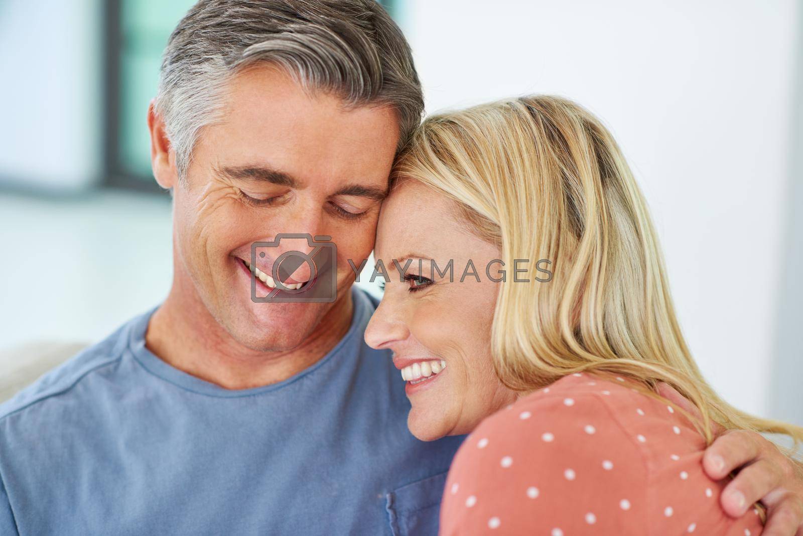 Royalty free image of All you need is love. Shot of a mature couple being affectionate at home. by YuriArcurs