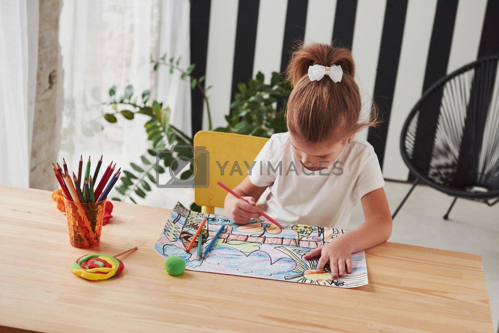 Royalty free image of Concentrated at work. Cute little girl in art school draws her first paintings by pencils and markers by Standret