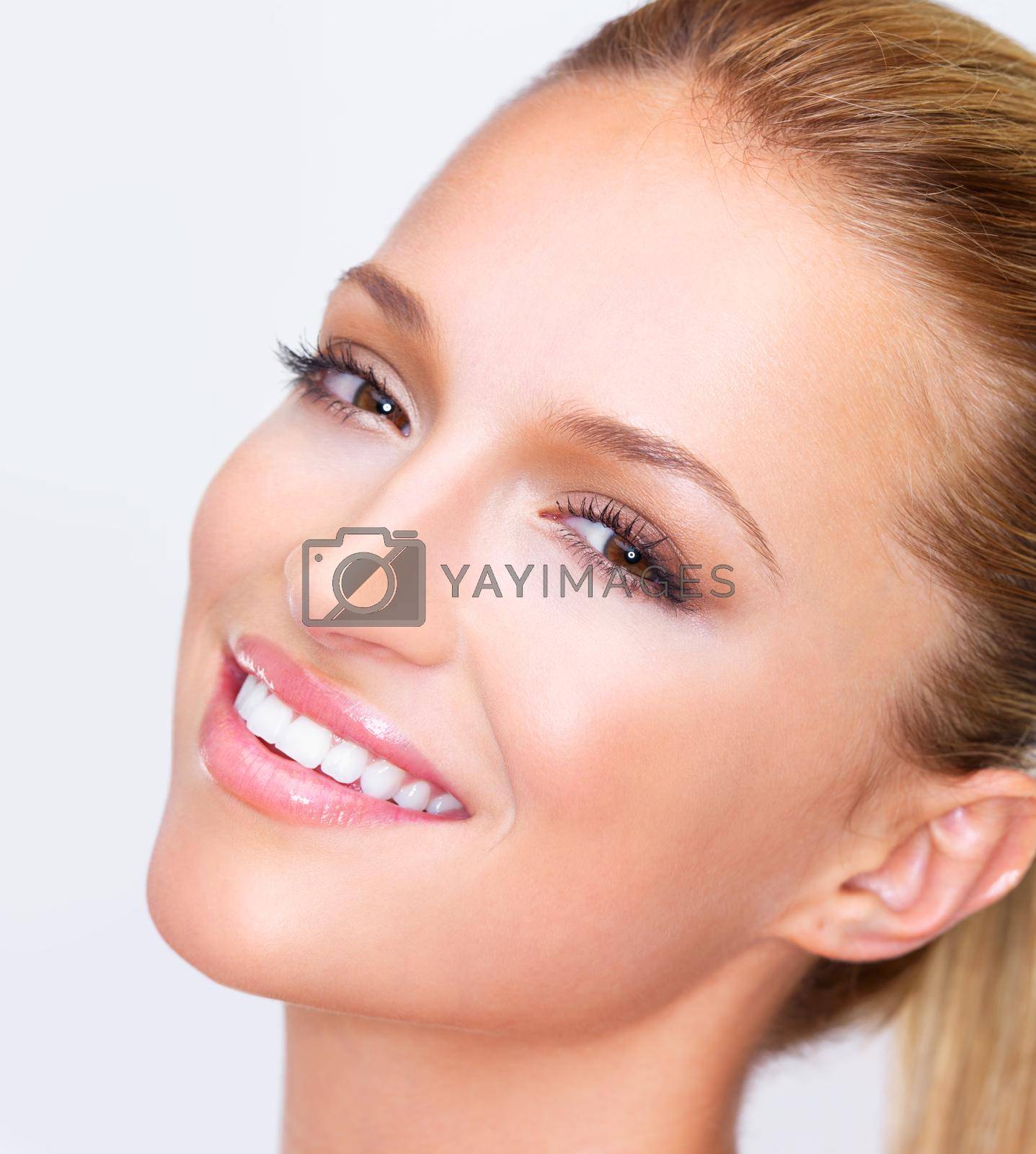 Cropped closeup of a naturally beautiful woman with flawless skin smiling at you, isolated on white.