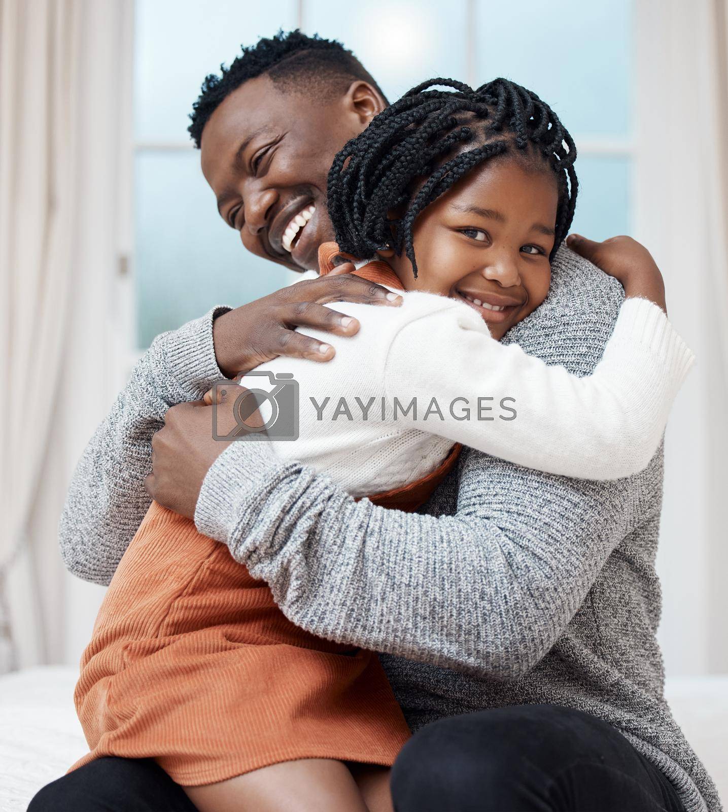 Shot of a young father hugging his daughter while bonding at home.