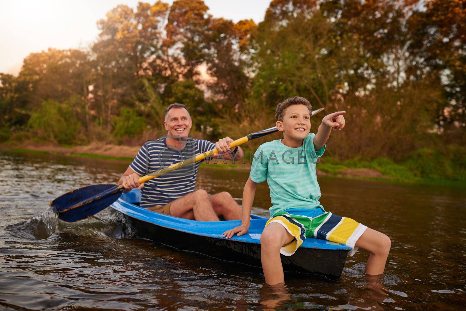 Shot of a father and son rowing a boat together on a lake.