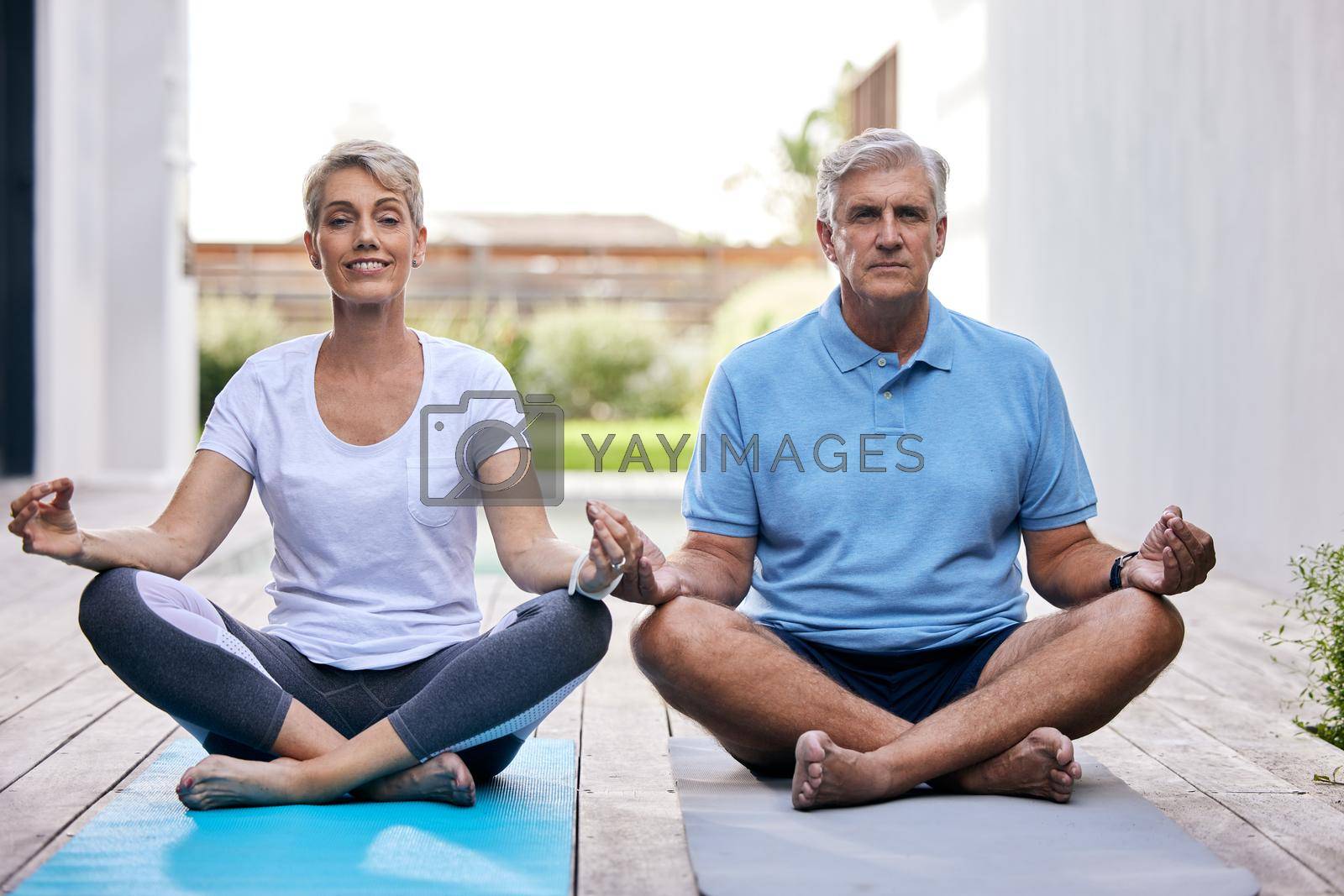 Shot of a mature couple meditating together outdoors.