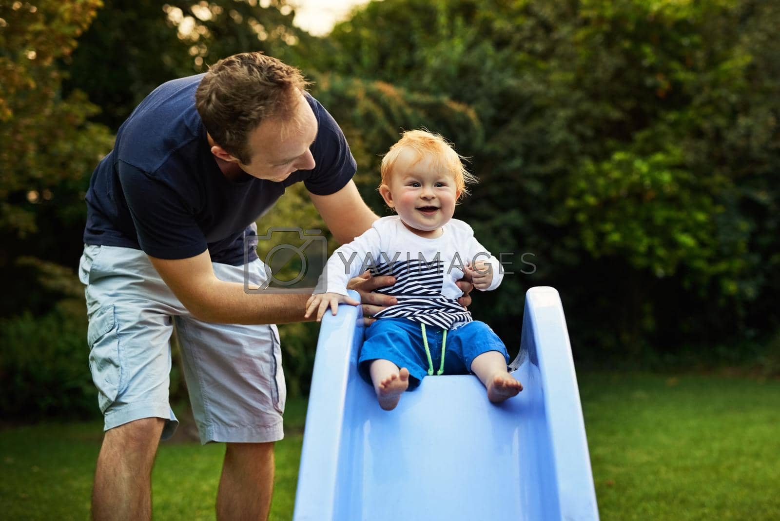 Shot of an adorable little boy and his father playing in the backyard.
