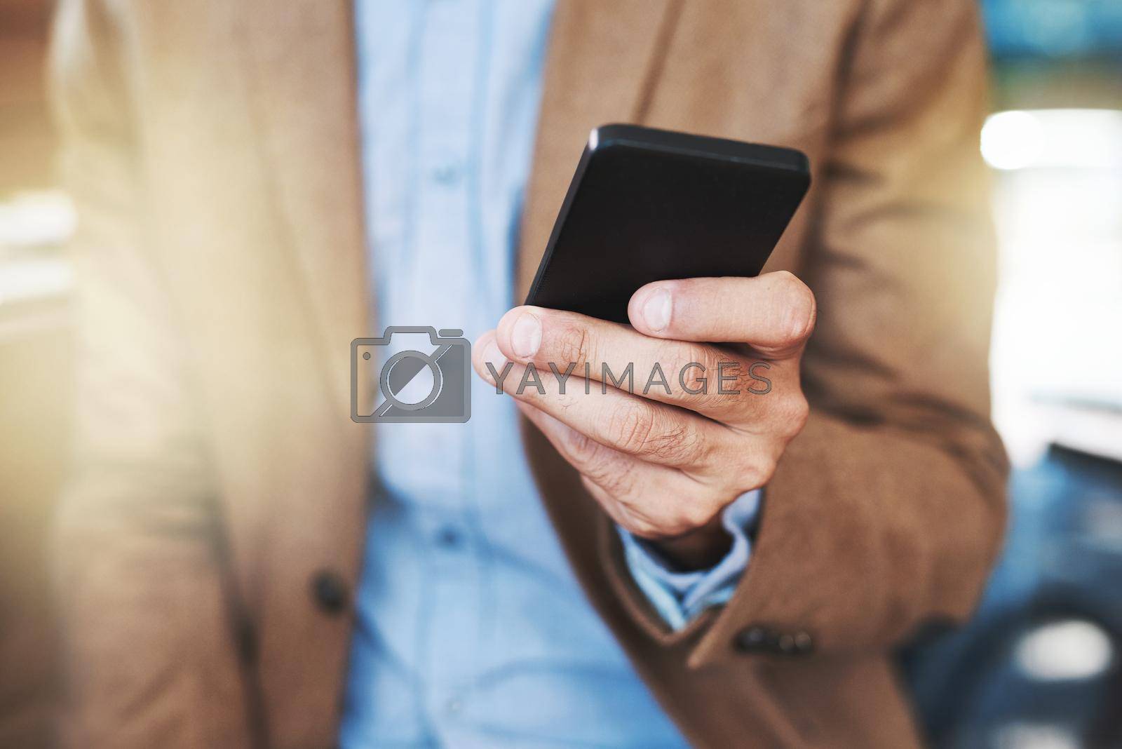 Cropped shot of a businessman using a mobile phone.