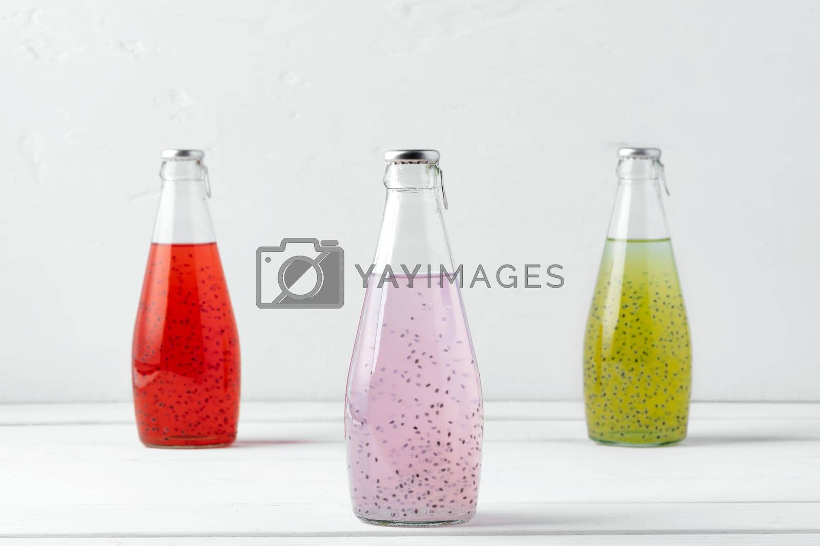 Basil seed drink in glass bottles on white background, close up