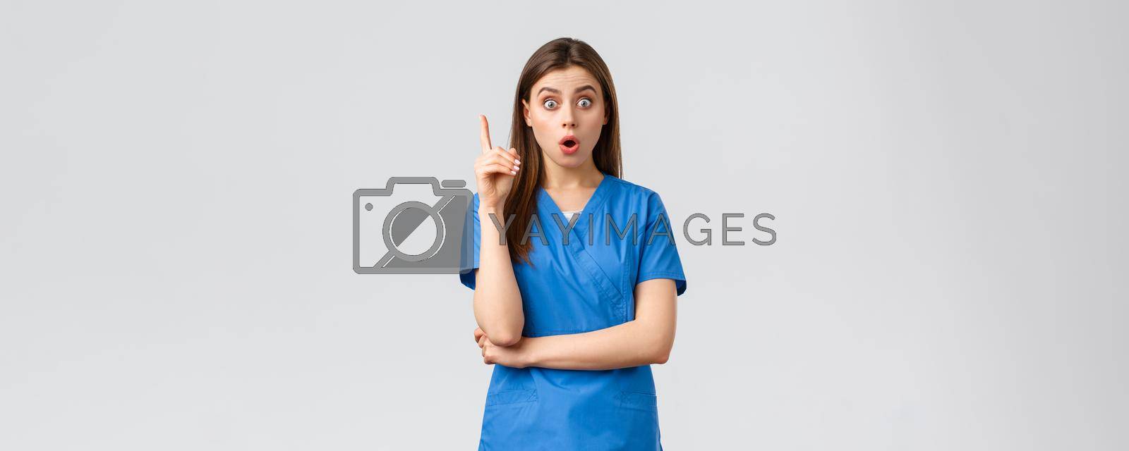 Healthcare workers, prevent virus, insurance and medicine concept. Excited female nurse or doctor in blue scrubs lift one finger, have idea, great thought or suggestion, found solution.
