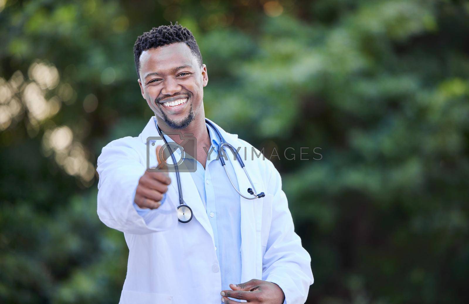 Shot of a young male doctor showing a thumbs up in nature.