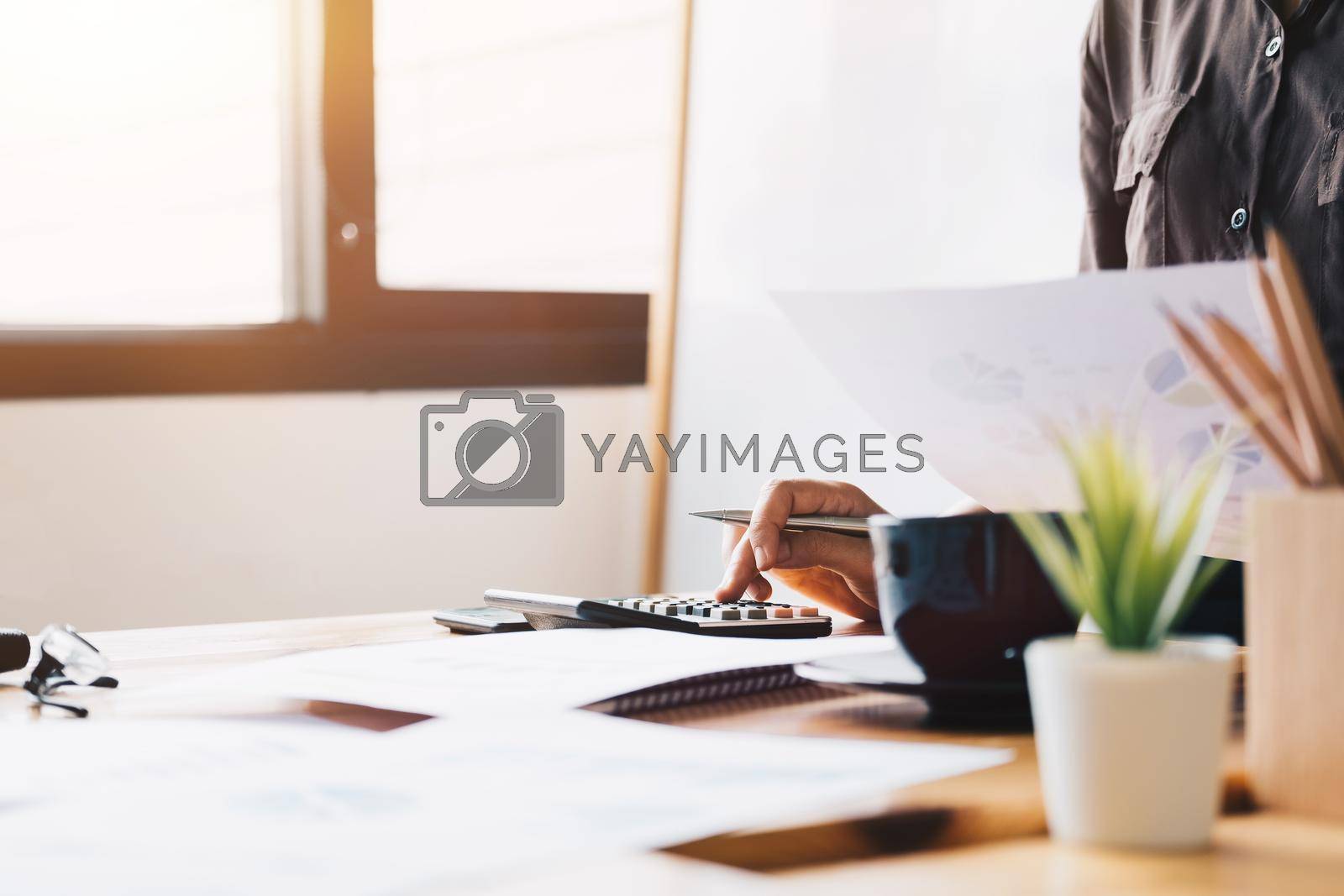 Royalty free image of Close up Business woman using calculator and laptop for do math finance by nateemee