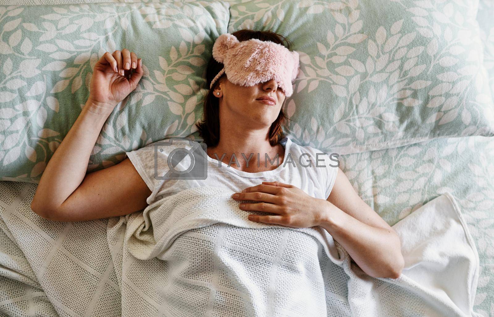 Shot of an attractive young woman sleeping with a sleep mask on in her bed at home.