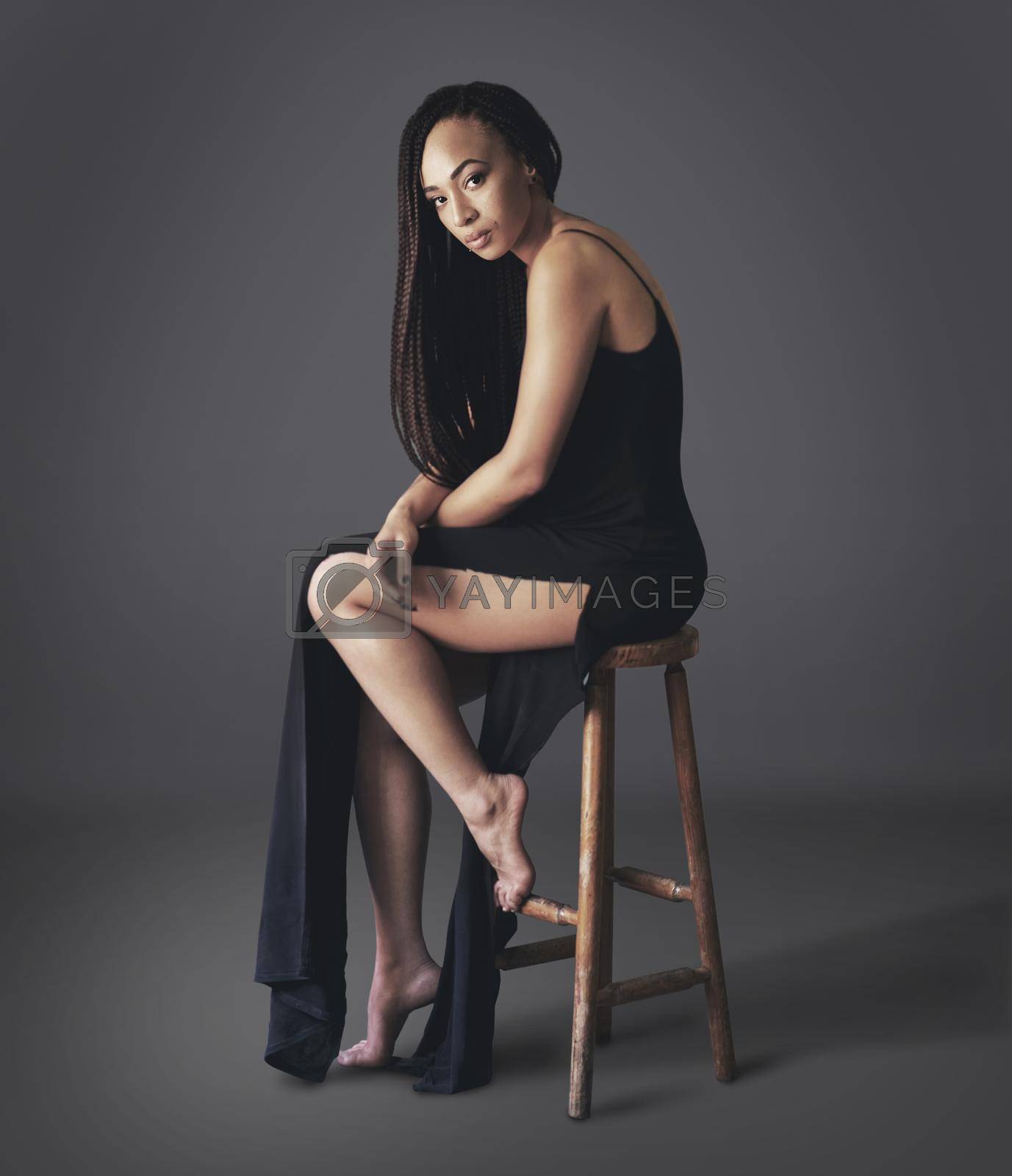 Royalty free image of Simplicity is the essence of beauty. Studio shot of a beautiful young woman sitting on a chair against a gray. by YuriArcurs