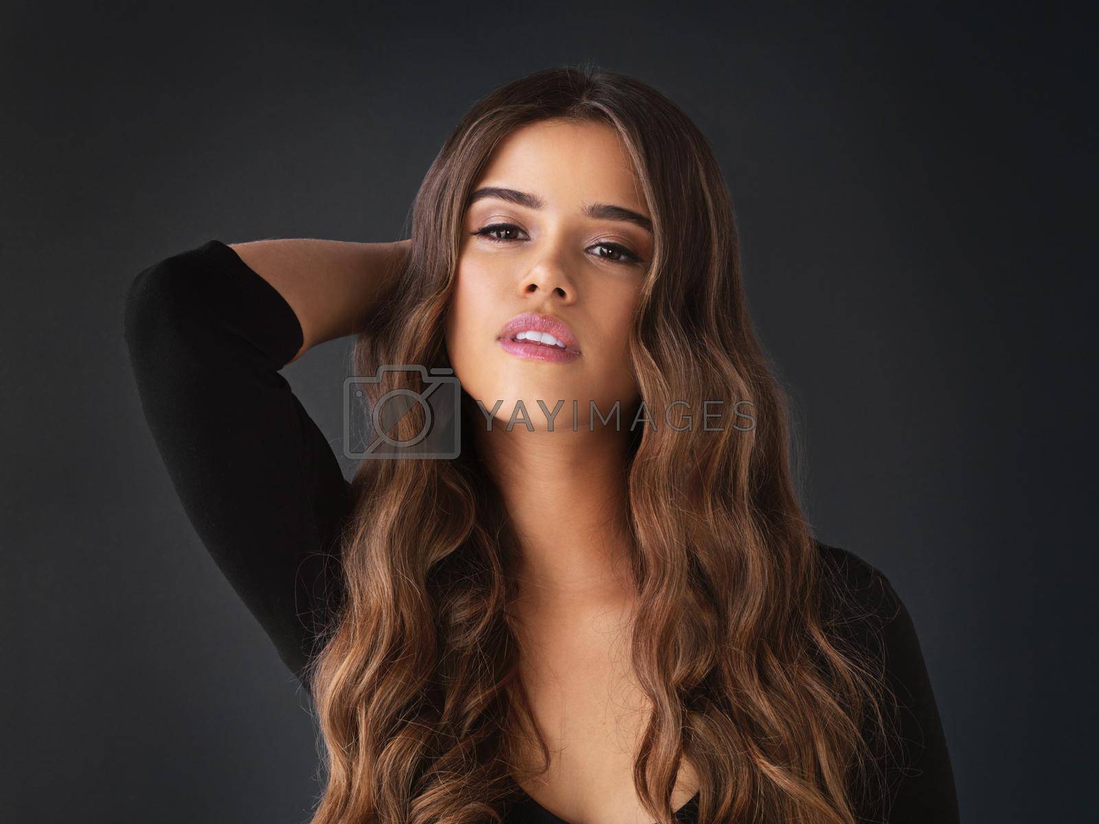 Studio shot of a beautiful young woman against a dark background.