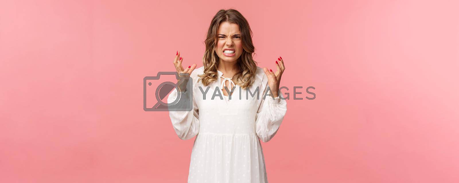 Royalty free image of Portrait of woman losing control over emotions, feel pressured and tensed, lose temper, clench hands into fists and stare aggressive with angry, outraged expression, hate someone badly by Benzoix