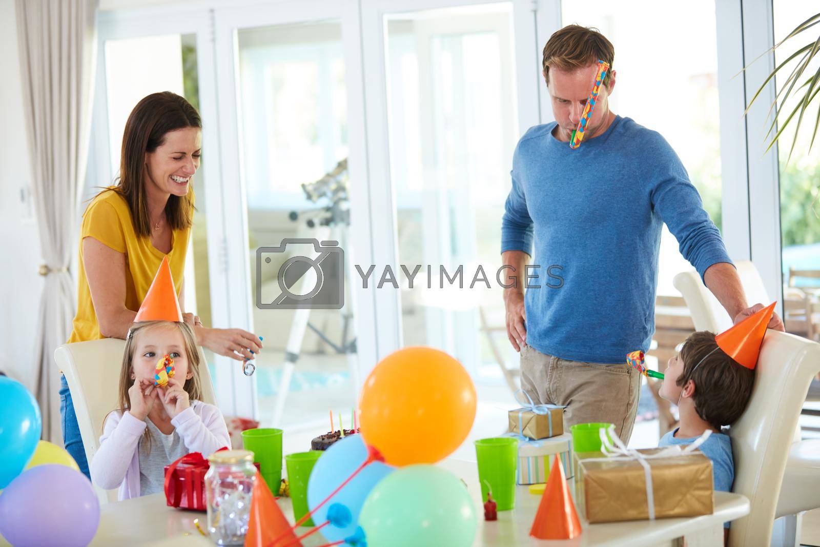 Shot of a happy family playing with party horns at a birthday party.