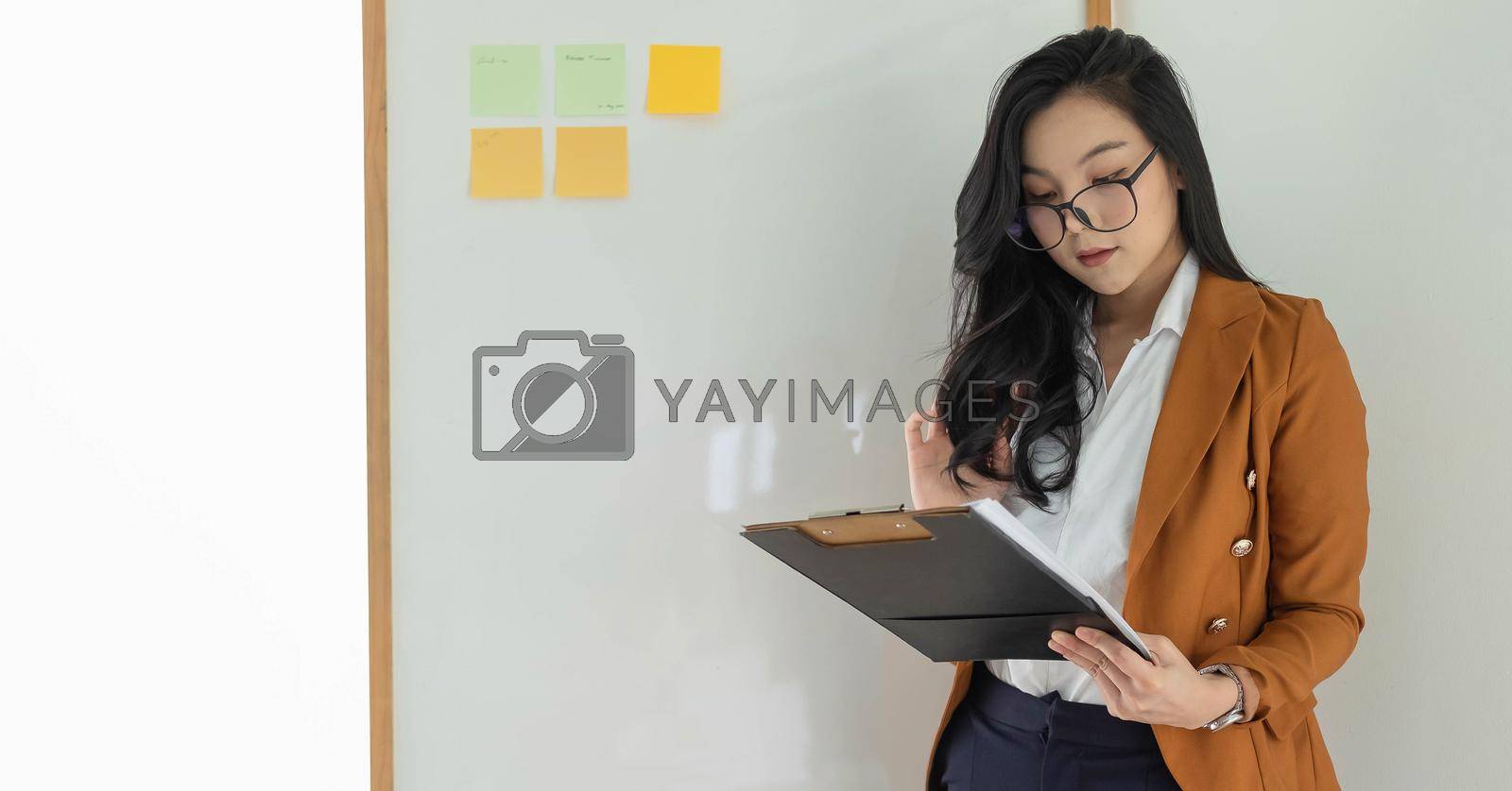 Young asian business woman entrepreneur looking at financial report in the office.