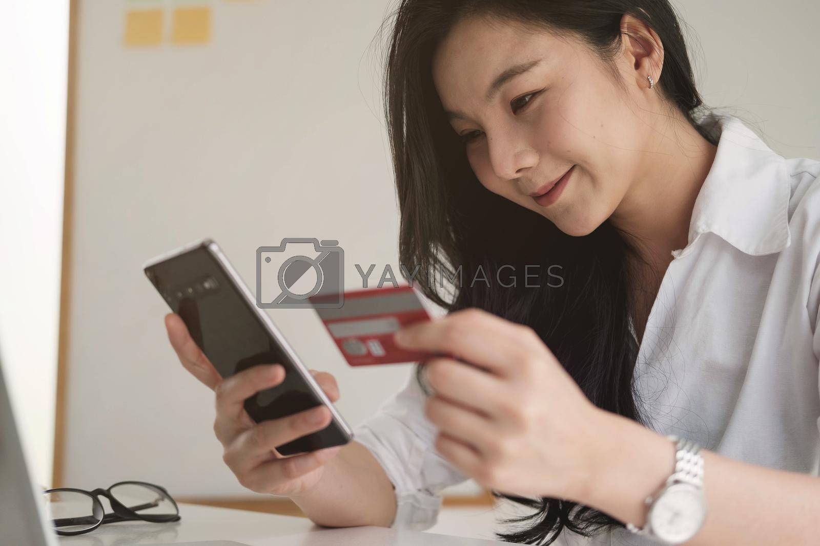 Royalty free image of Shopping online with smartphone and credit card on hand by nateemee