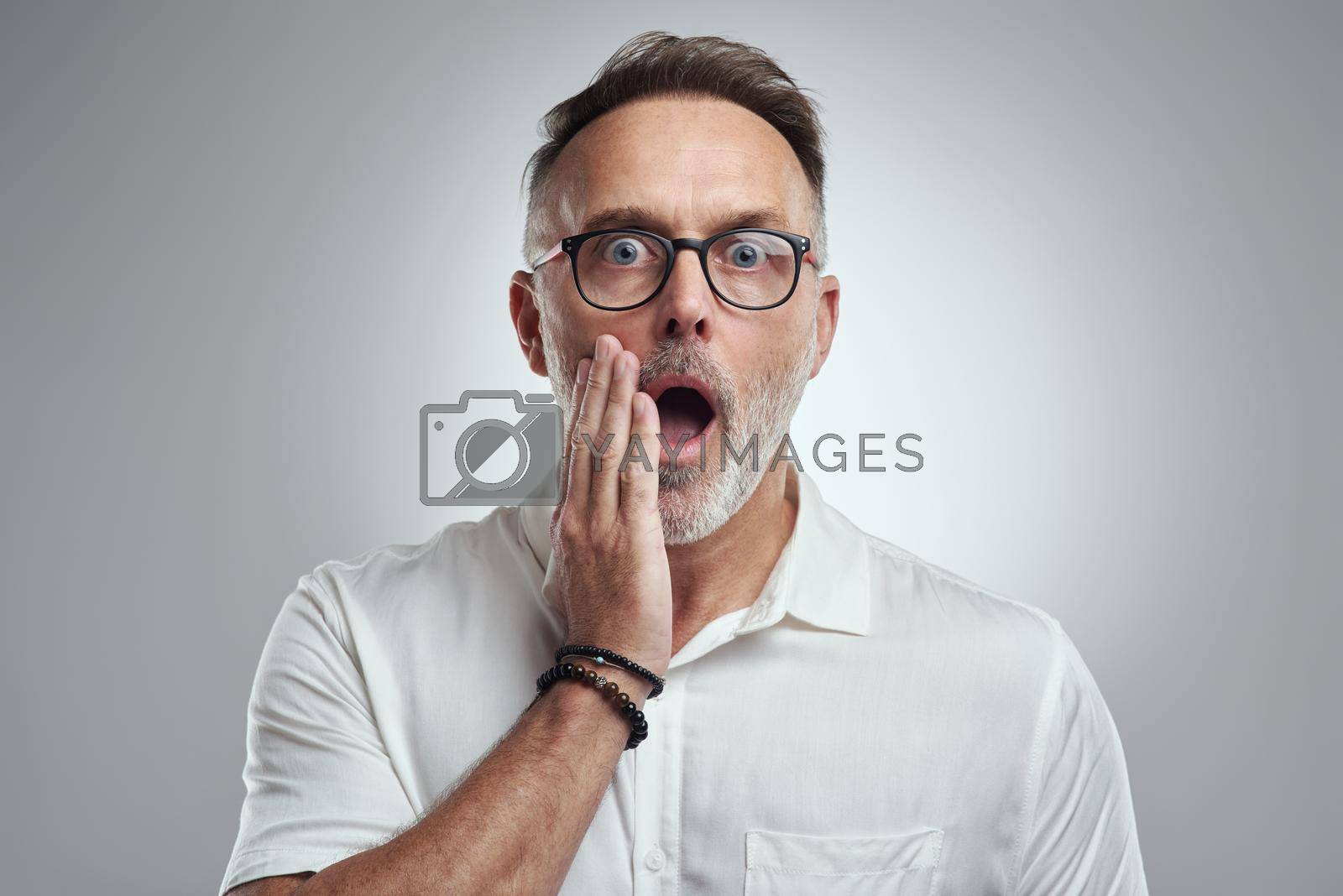 Royalty free image of I am beyond shocked. Studio portrait of a mature man looking surprised against a grey background. by YuriArcurs