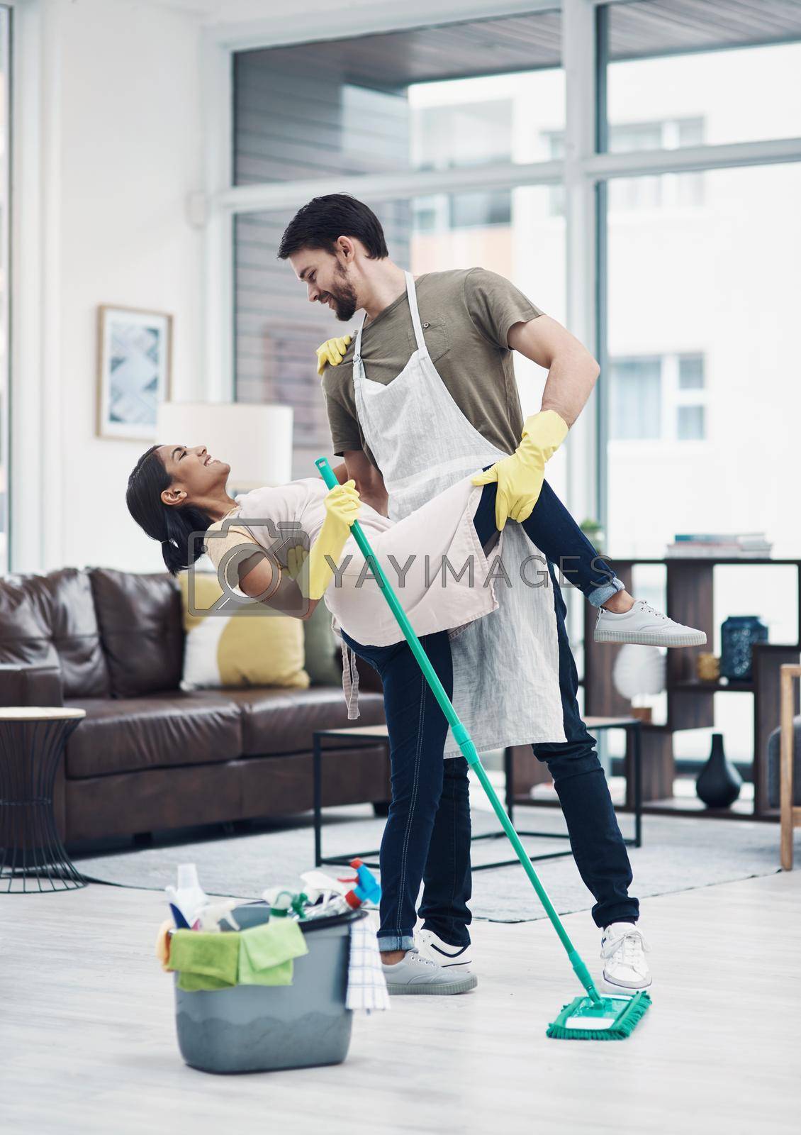 Shot of a happy young couple dancing while mopping the floor at home.