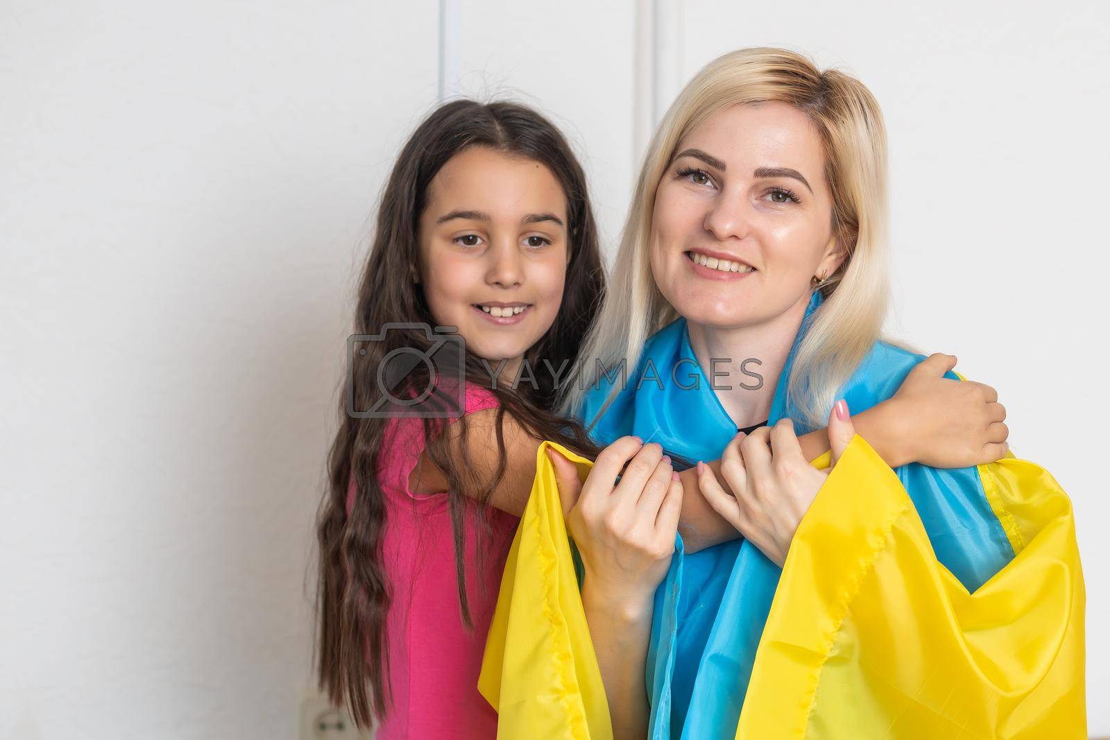 mother and daughter with ukraine flag.