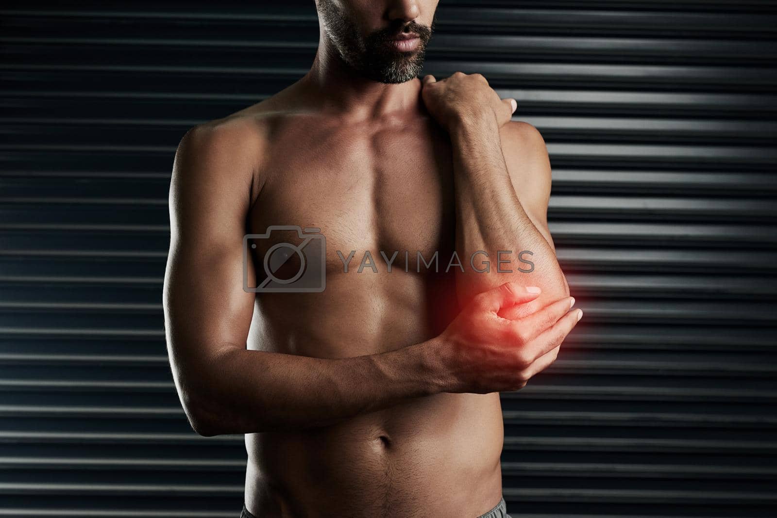 Royalty free image of Worked out a little too hard today.... Studio shot of a muscular young man with cgi highlighting an inflammation in his elbow. by YuriArcurs