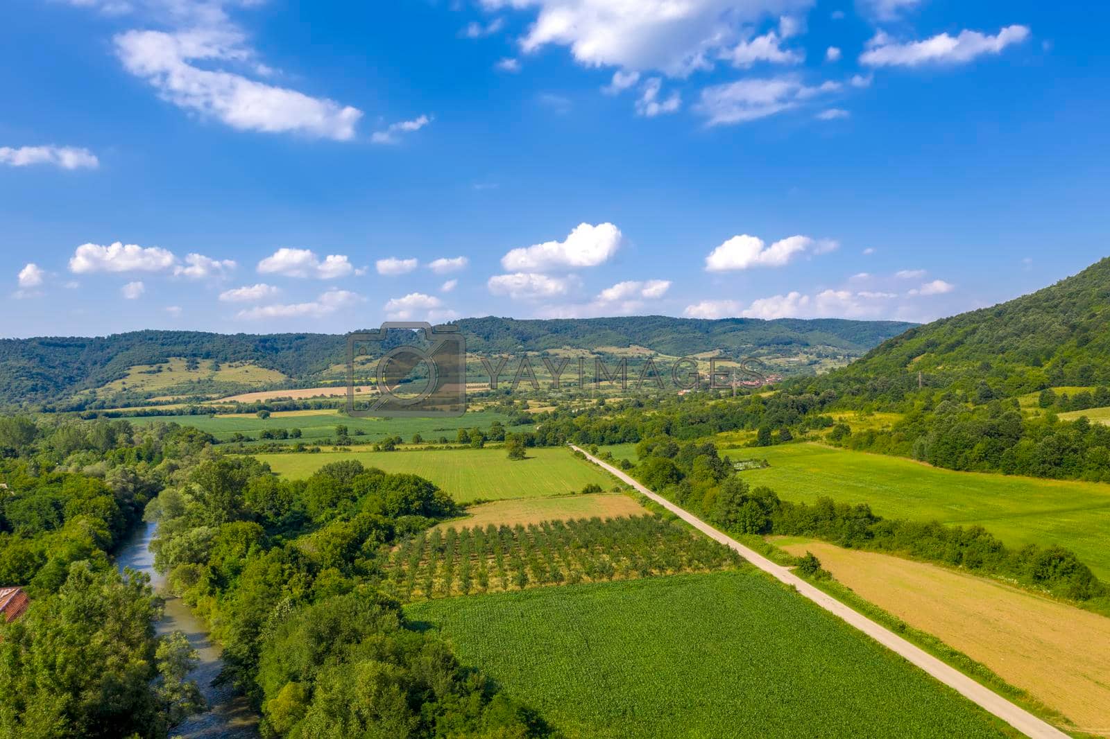 Aerial view from drone of the vast green landscape with river and hills
