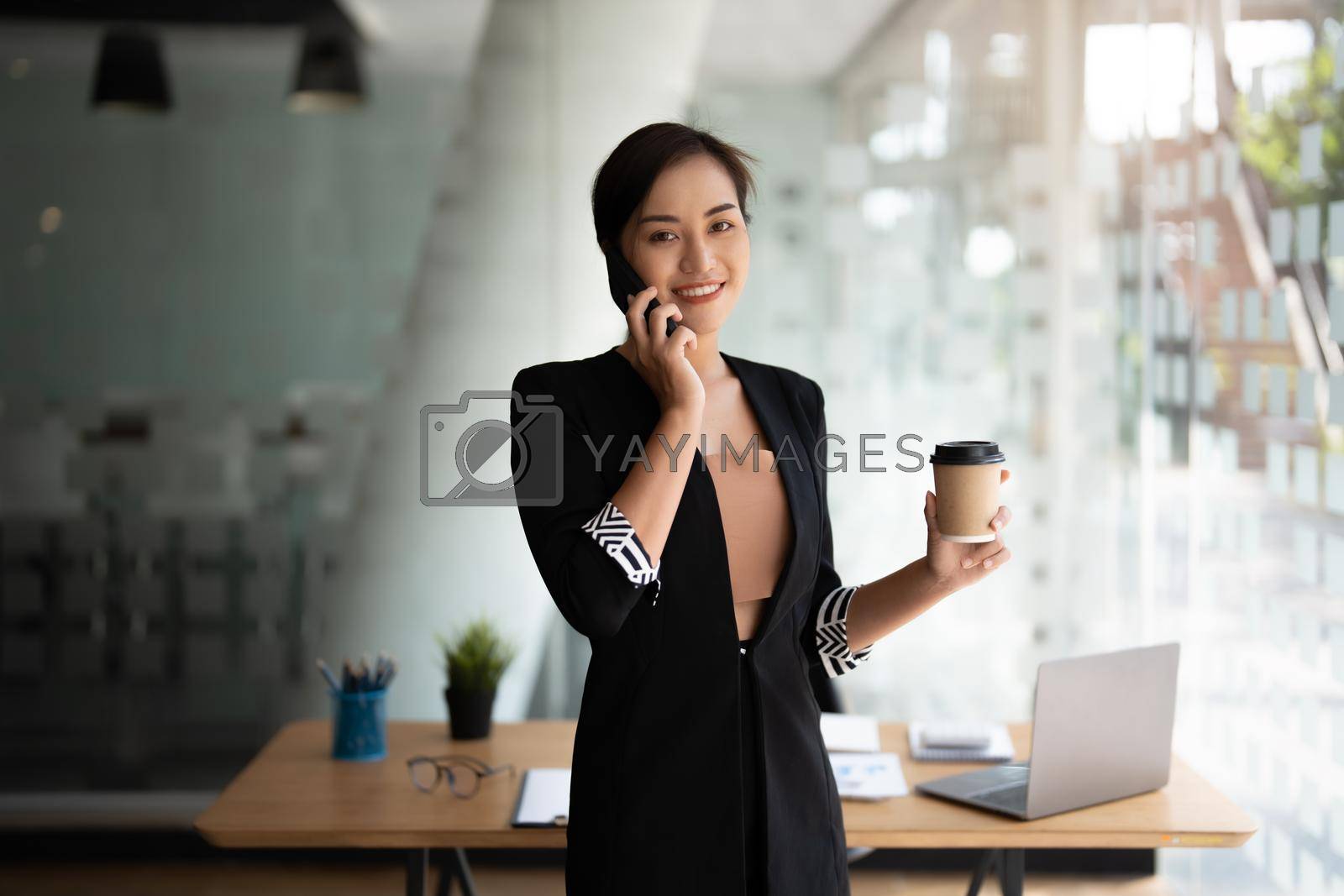 Royalty free image of Portrait business asian woman standing while talking with mobile phone. by nateemee