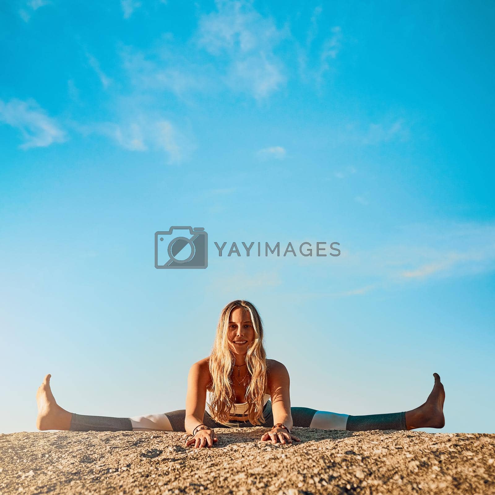 Shot of an athletic young woman practicing yoga on the beach.