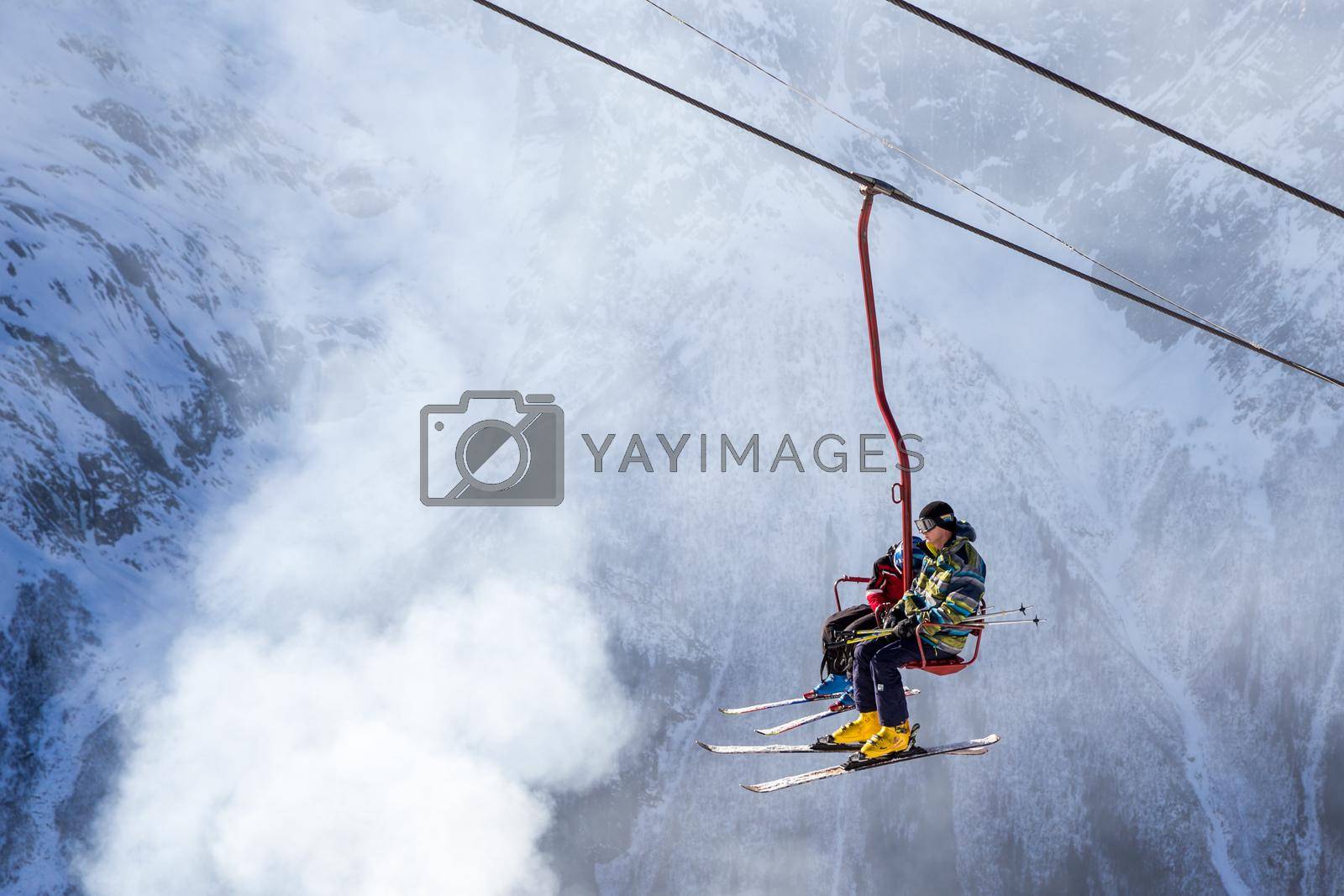 DOMBAI, RUSSIA - JANUARY 3, 2014: Tourists getting high up on ski lift in Caucasus mountains in Russia