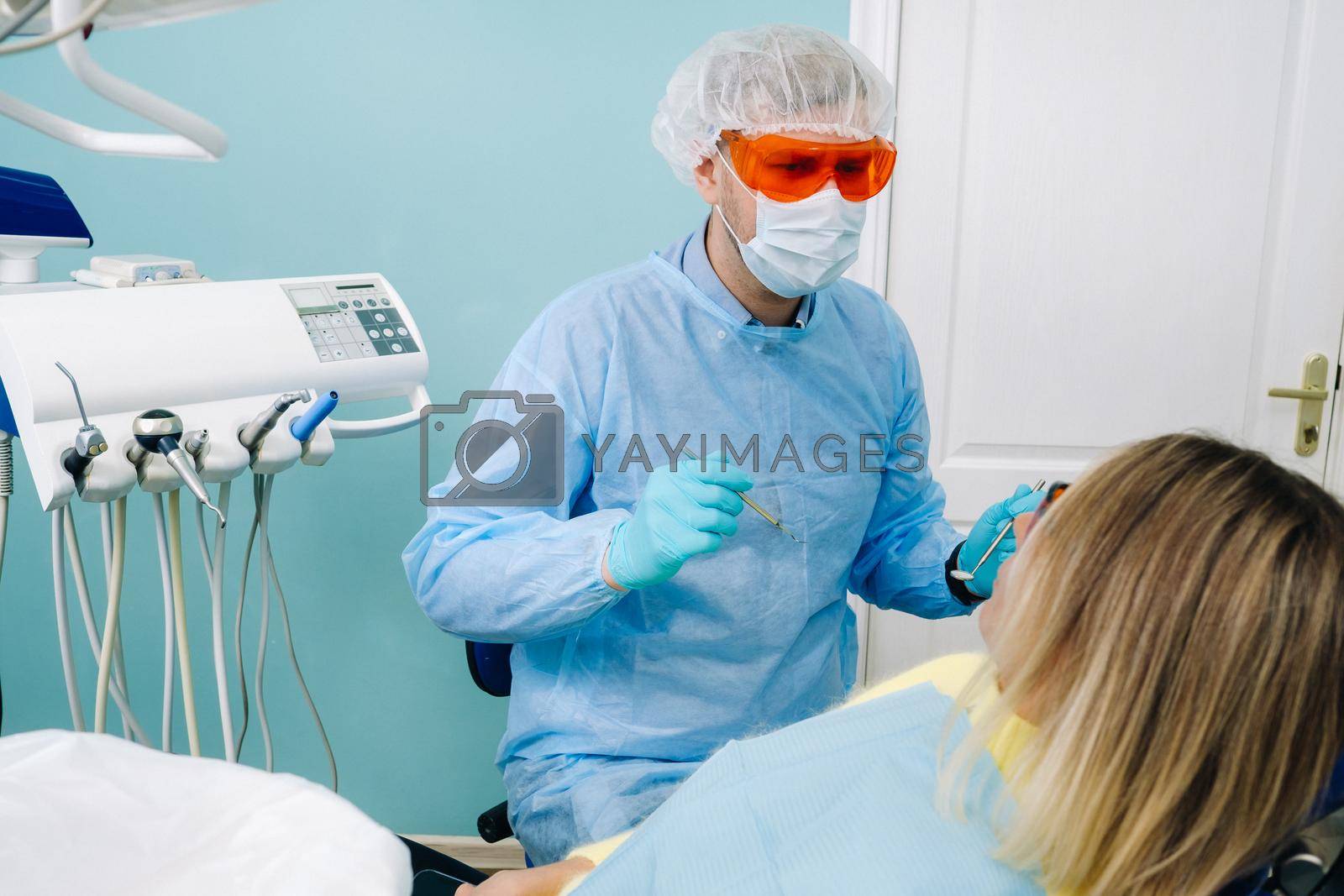 The patient treats her teeth at the dentist in the dental office . Dental fillings.