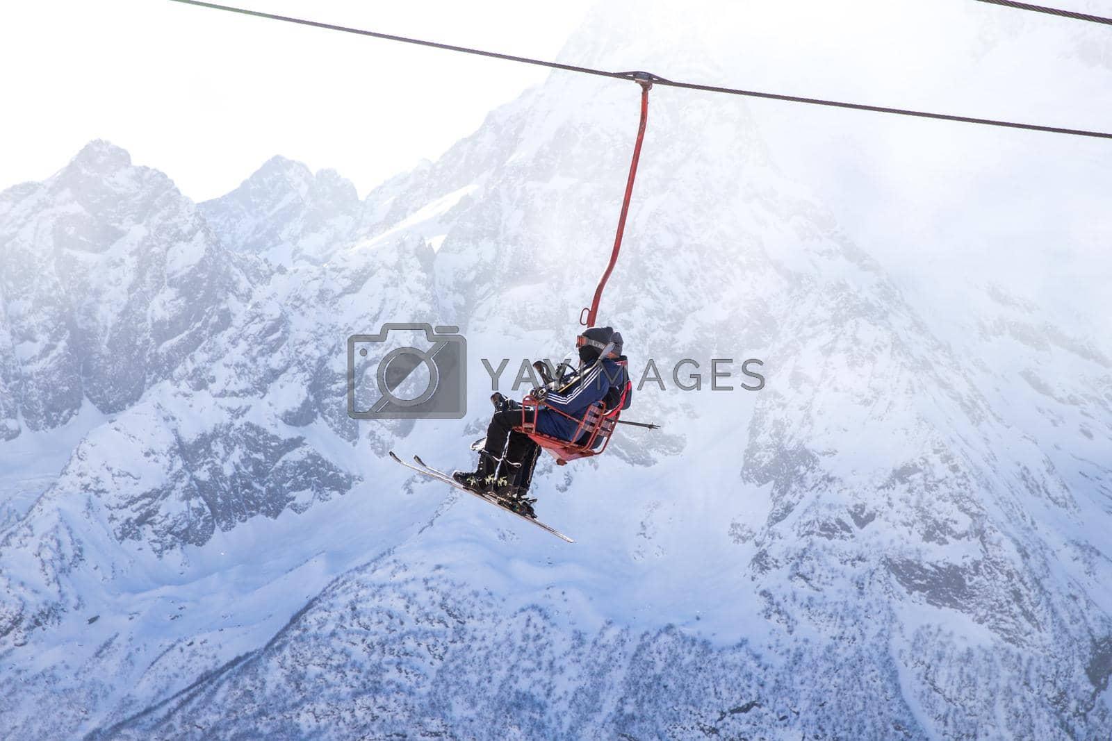 DOMBAI, RUSSIA - JANUARY 3, 2014: Tourists getting high up on ski lift in Caucasus mountains in Russia