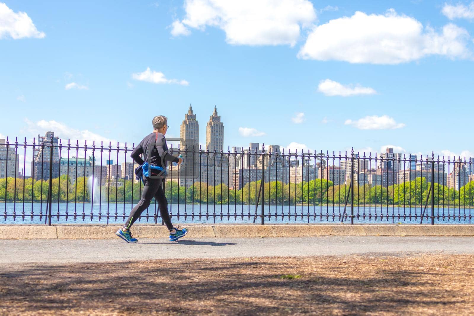 NEW YORK, USA - 15 MAY, 2019: Jogger running along Central Park reservoir in New York. Central Park is full of active people throughout the year