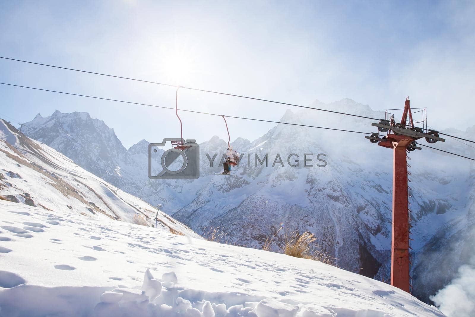 People are lifting on ski lift in the mountains