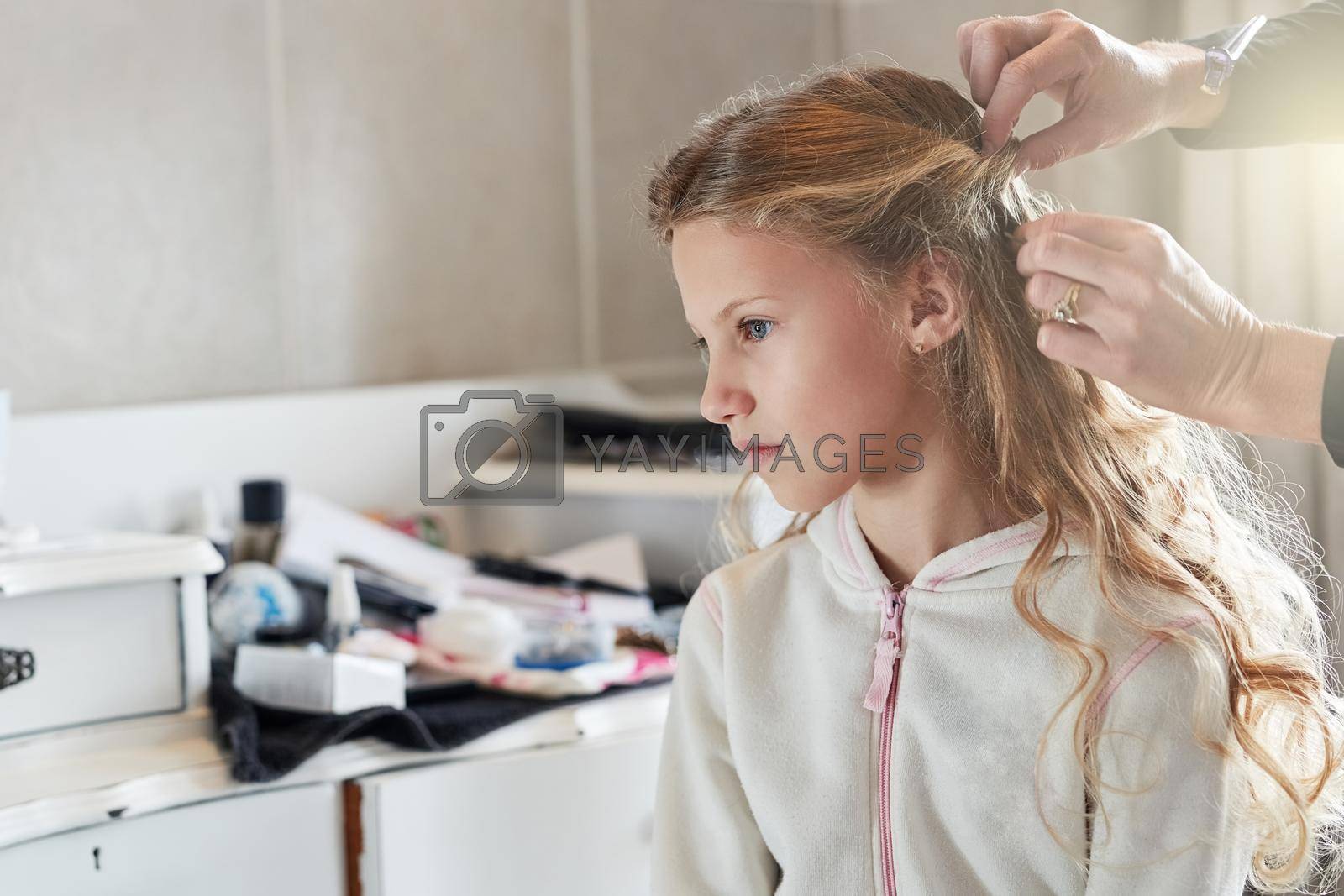 Shot of a little girl getting her hair done before a celebration event.
