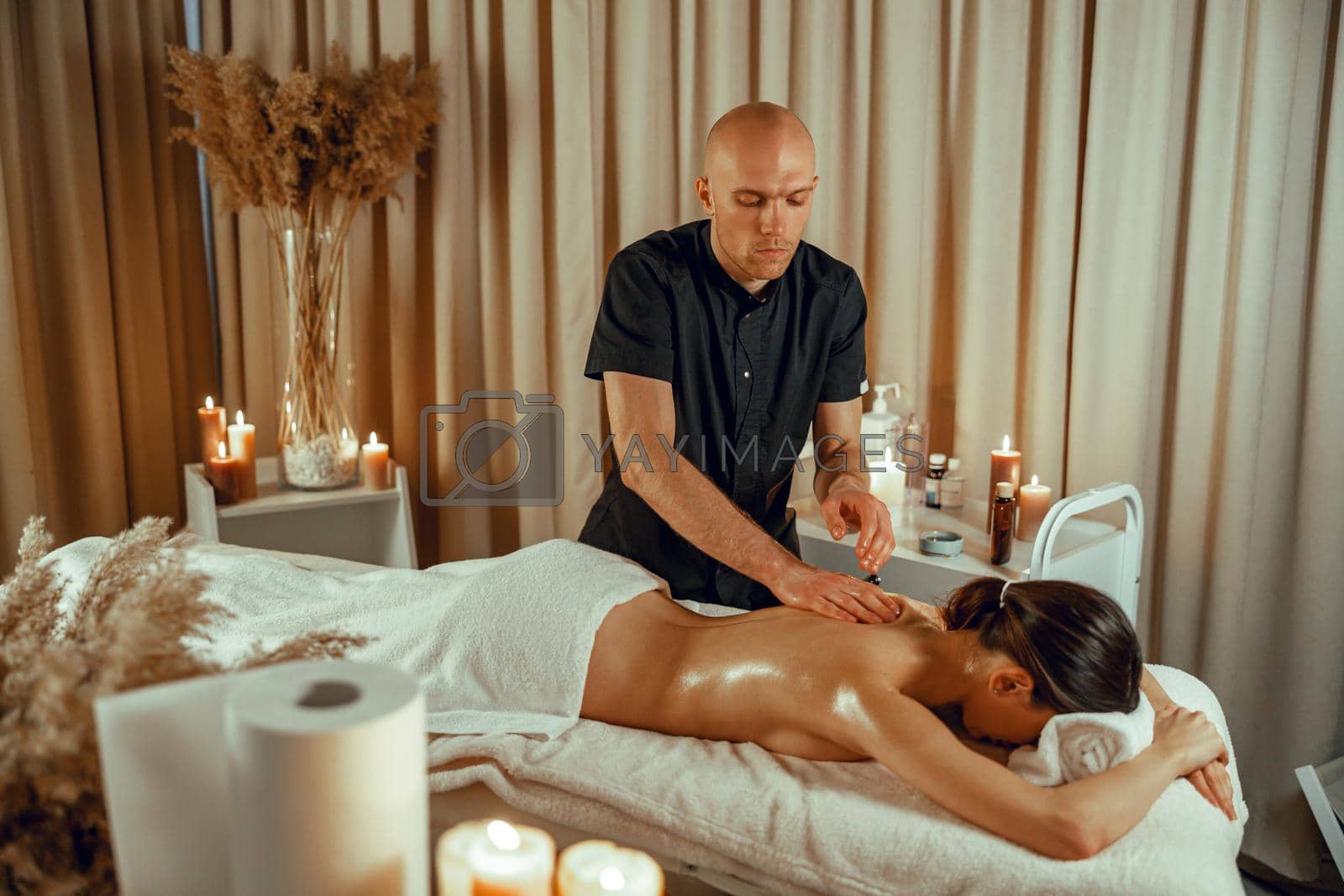Professional masseur man doing back massage at beauty spa resort. Treatment