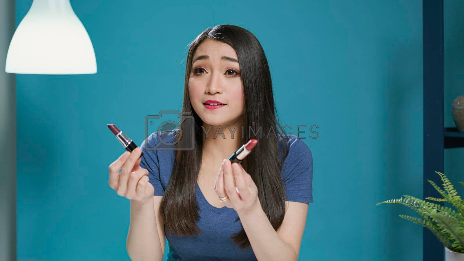 Beauty influencer recommending makeup products on camera, filming vlog to review lipstick cosmetics. Young blogger broadcasting video tutorial for lifestyle tips, vlogging on web.