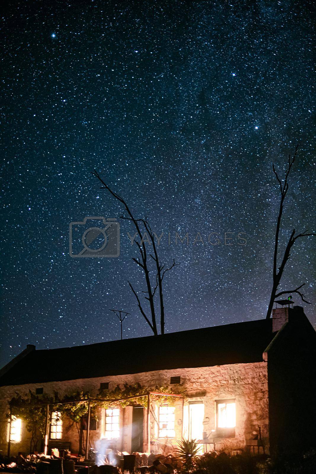 Shot of a house in the countryside on a dark starry night.