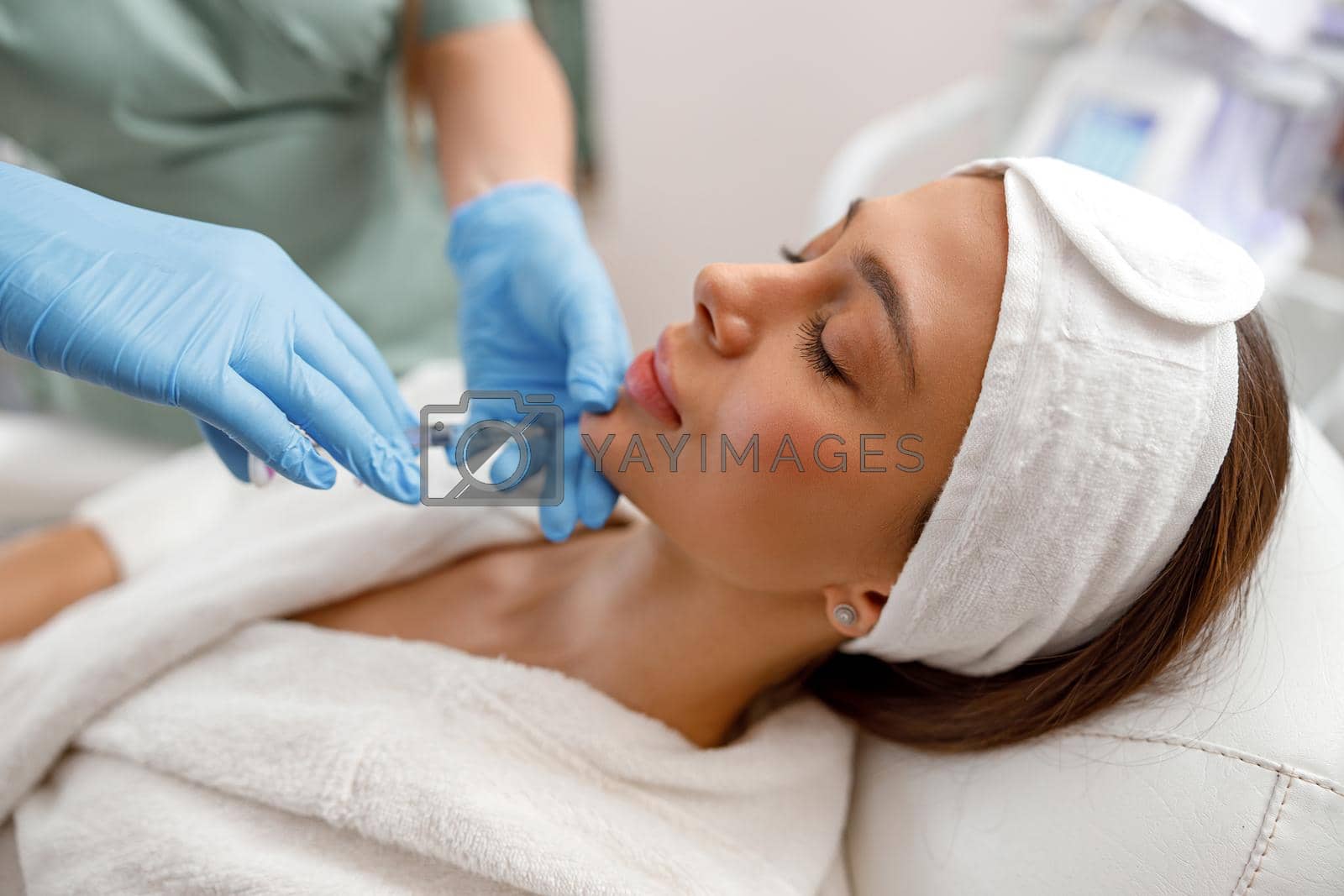 Young woman receiving hyaluronic acid injection in beauty salon. Cosmetology