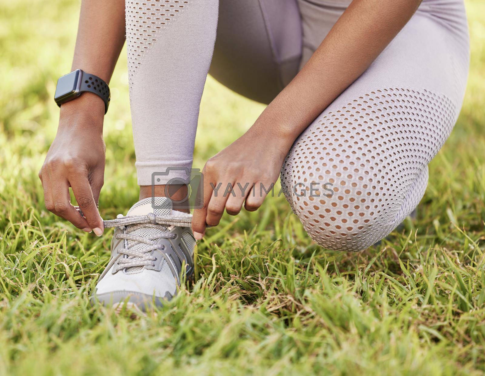Royalty free image of Its about at least having the determination to start. Closeup shot of an unrecognisable woman tying her shoelaces while exercising outdoors. by YuriArcurs