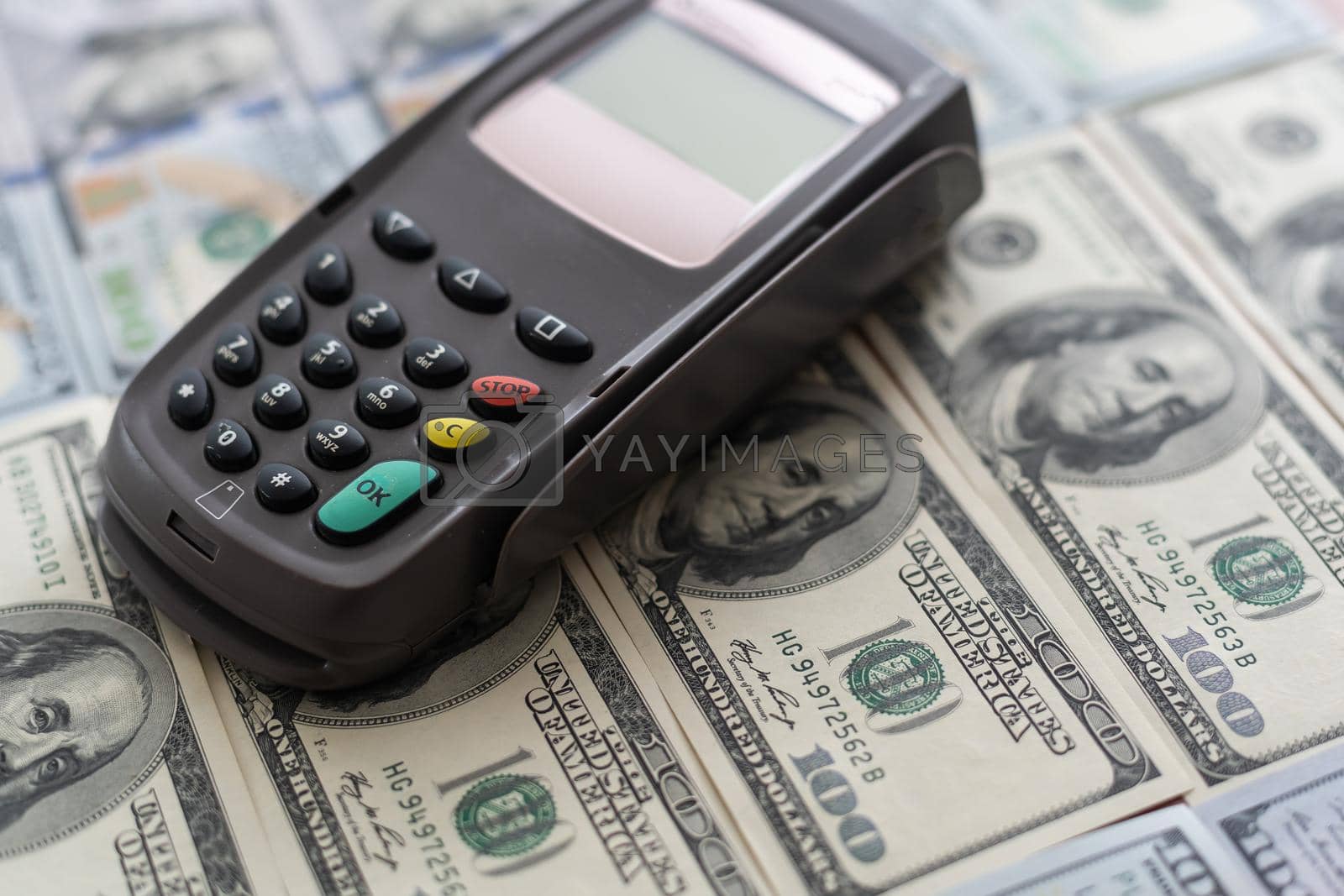 Terminal for cashless payments. Concept - refusal of cash transactions. Hundred dollar bills near cash register terminal. Concept - sale equipment for working with bank cards. Payment upon purchase.