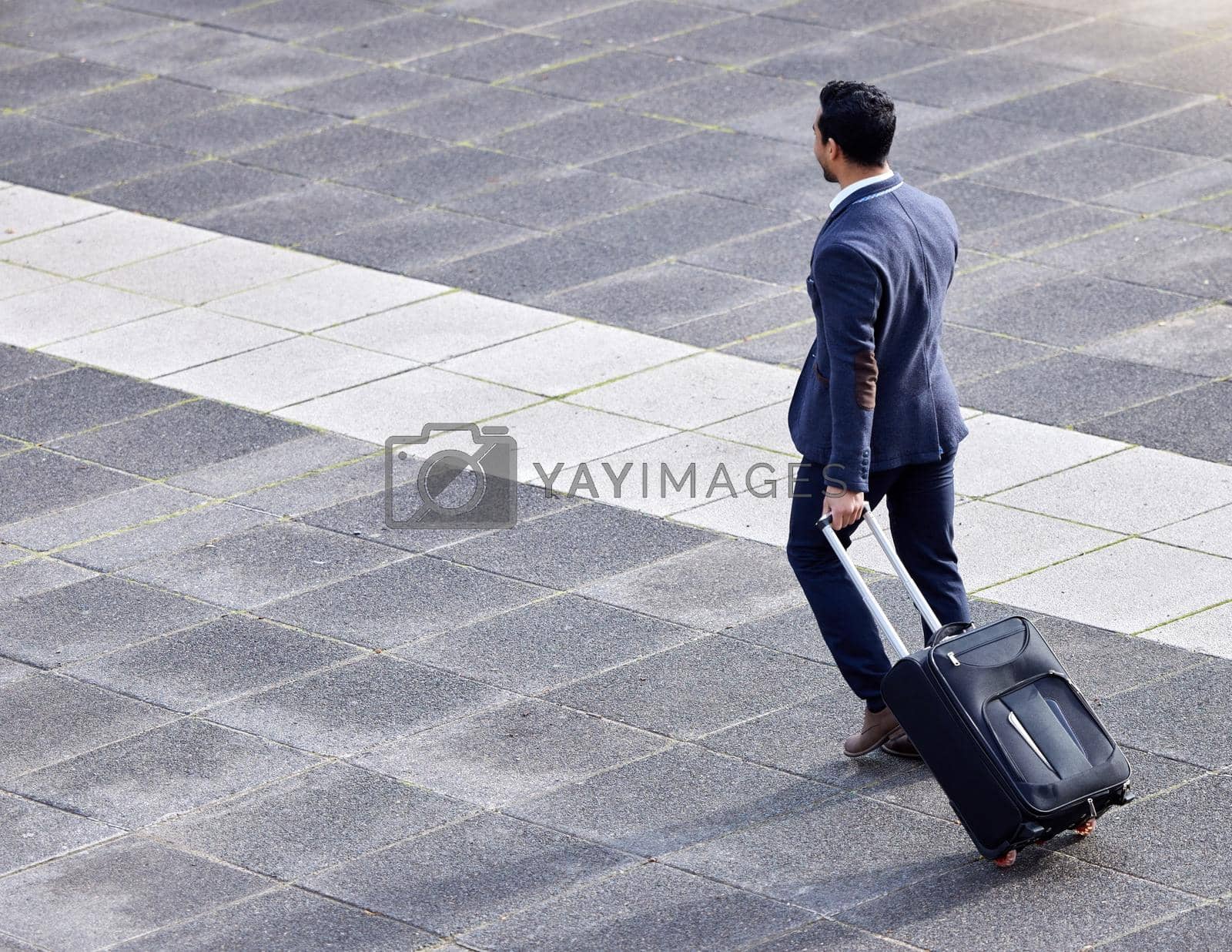 Shot of a businessman making his way to the airport with his suitcase.