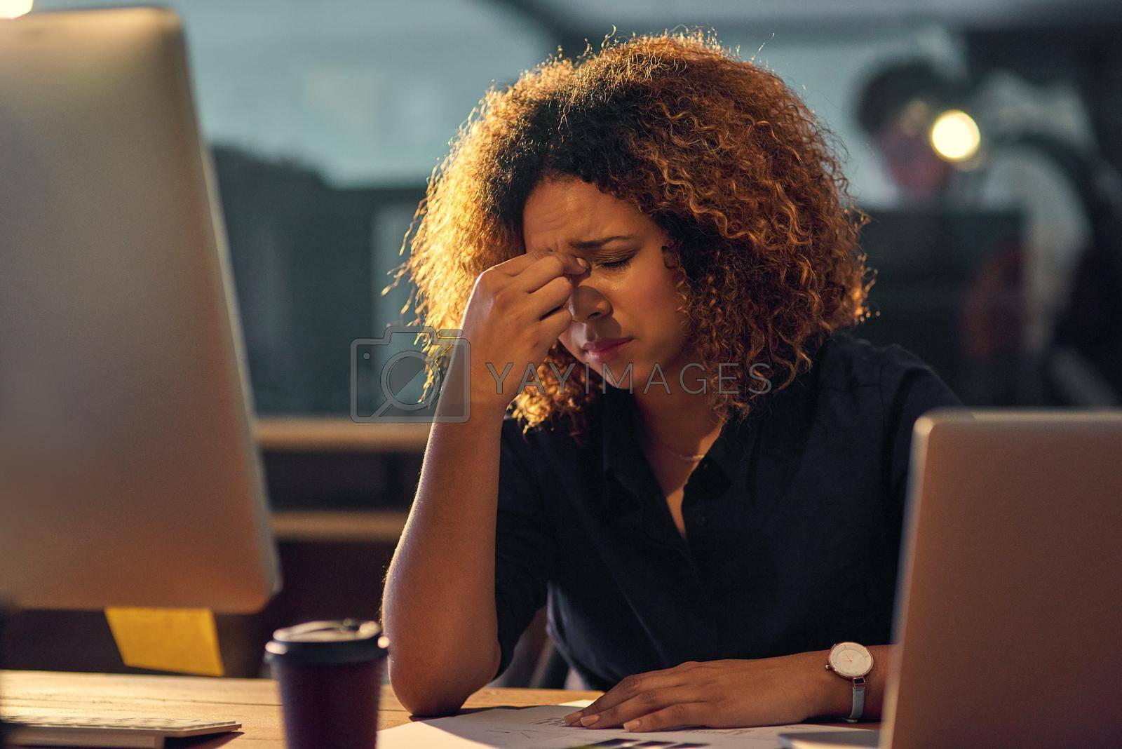 Royalty free image of In the grip of occupational stress. Shot of a young businesswoman experiencing stress during a late night at work. by YuriArcurs