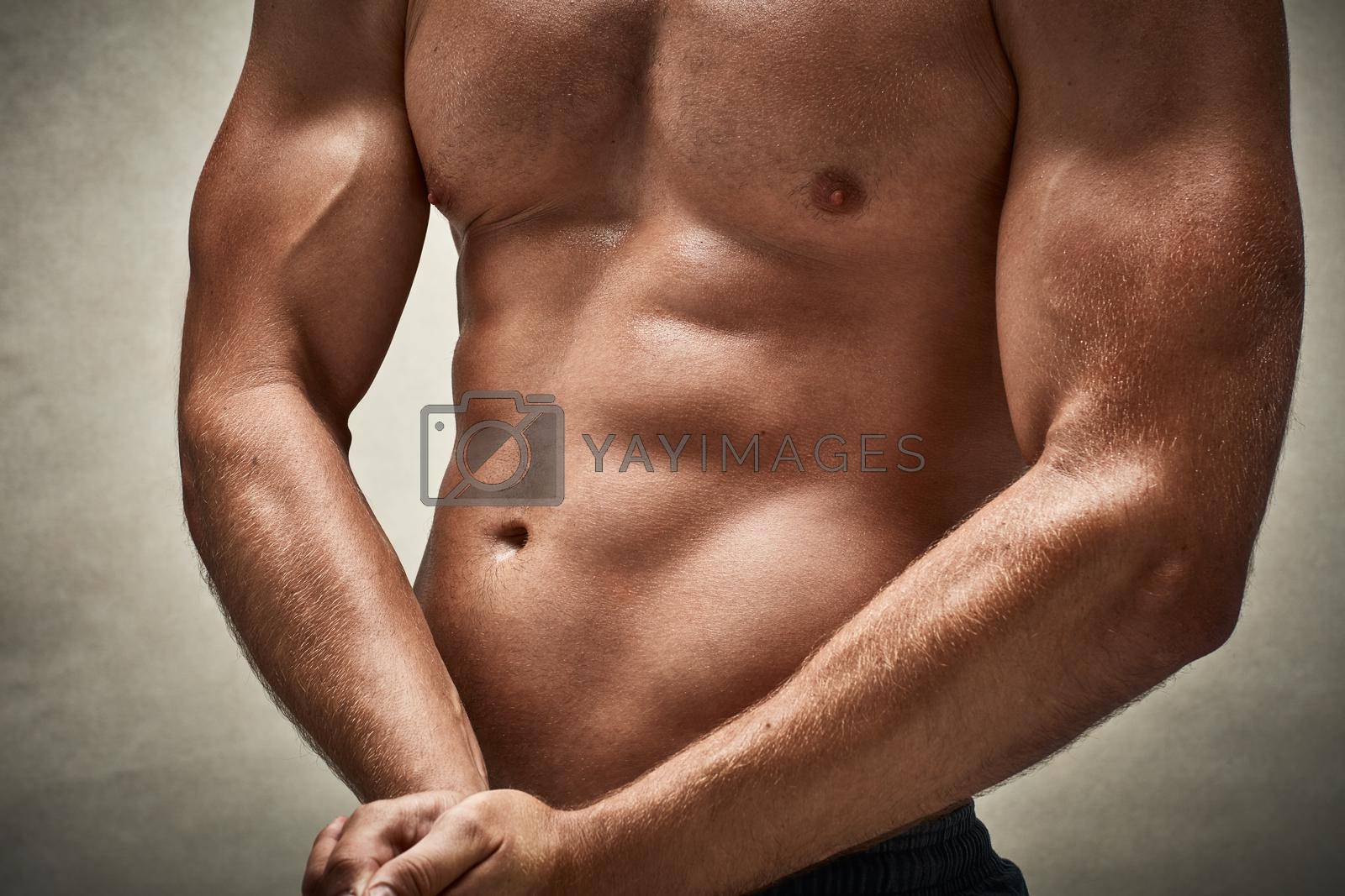 Royalty free image of Game changing muscles. Cropped studio shot of a muscular man flexing his muscles. by YuriArcurs