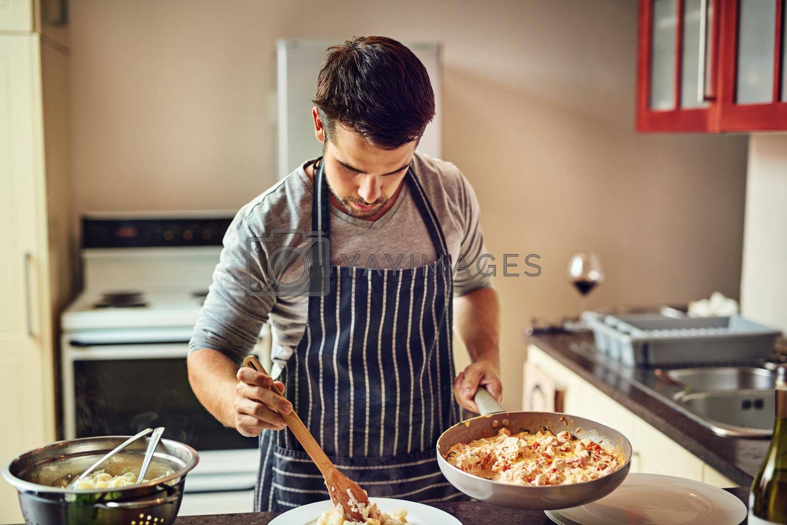Shot of a young man preparing food in the kitchen at home.
