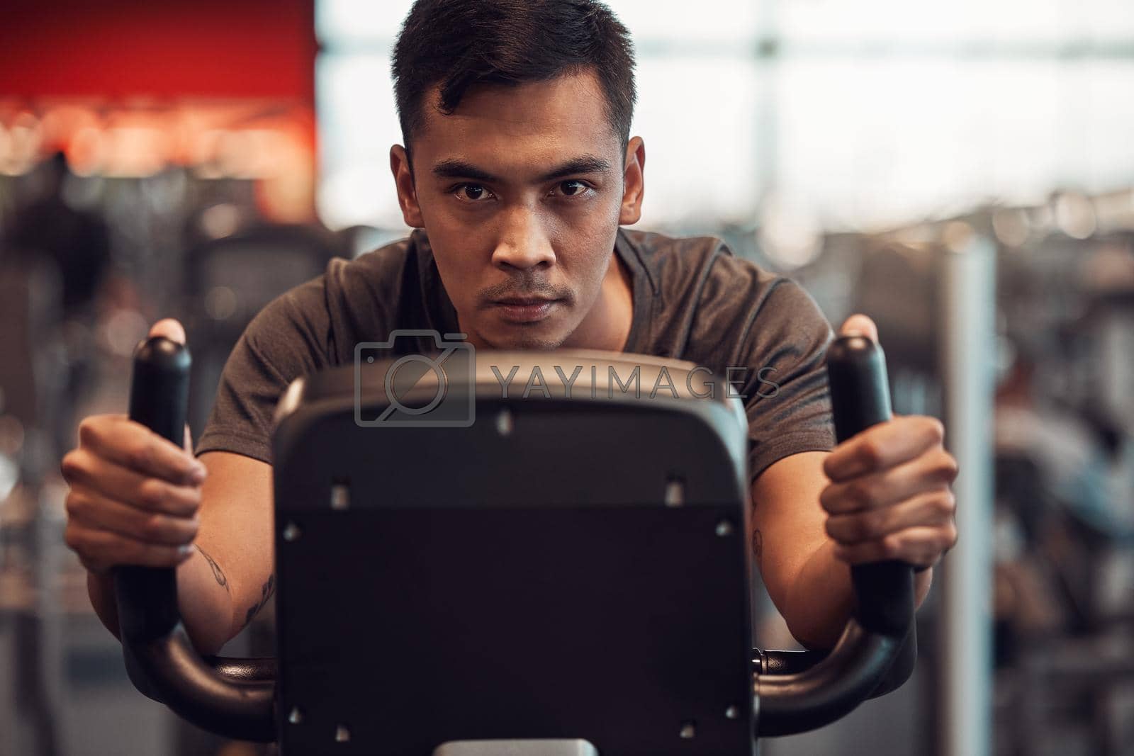 Royalty free image of Ridding my way to some tight calves. Shot of a young man using an exercise bike in the gym. by YuriArcurs